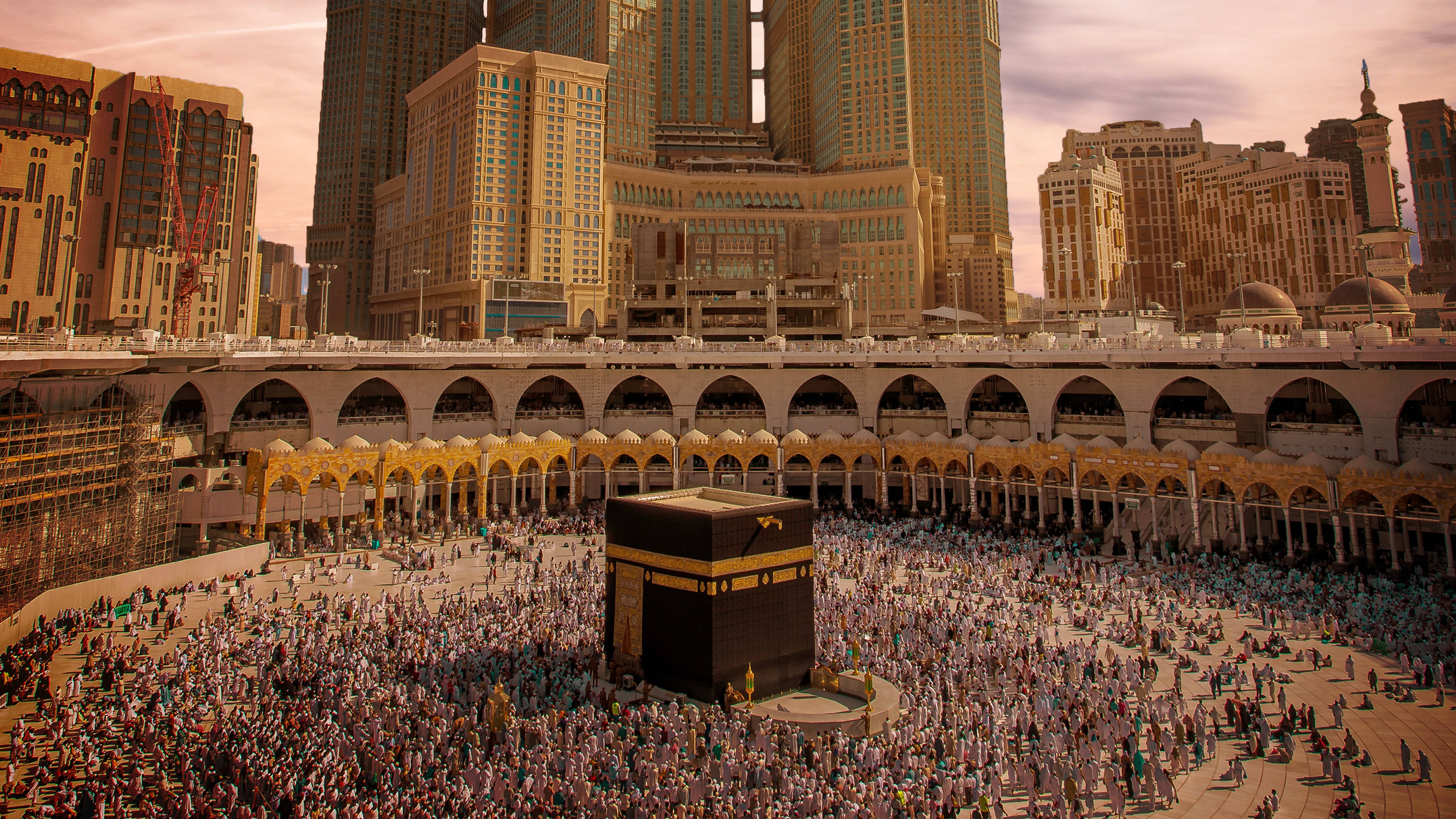 muslim 桌布 壁紙 — 在黃金時段，大量人群圍繞著麥加的天房，背景是高聳的摩天大樓。
