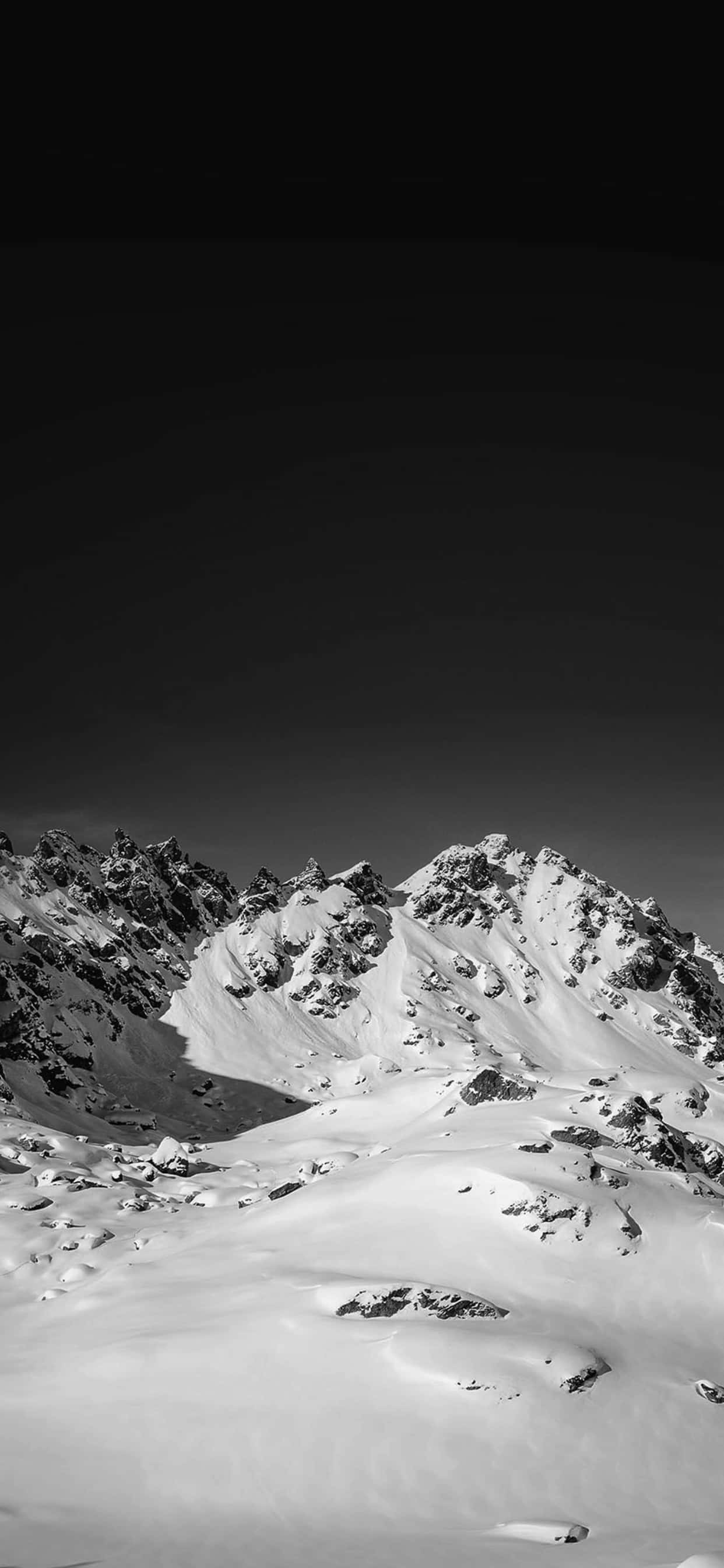 黑白 桌布 壁紙 — 在黑暗天空下，一個清晰的黑白山脈被雪覆蓋。