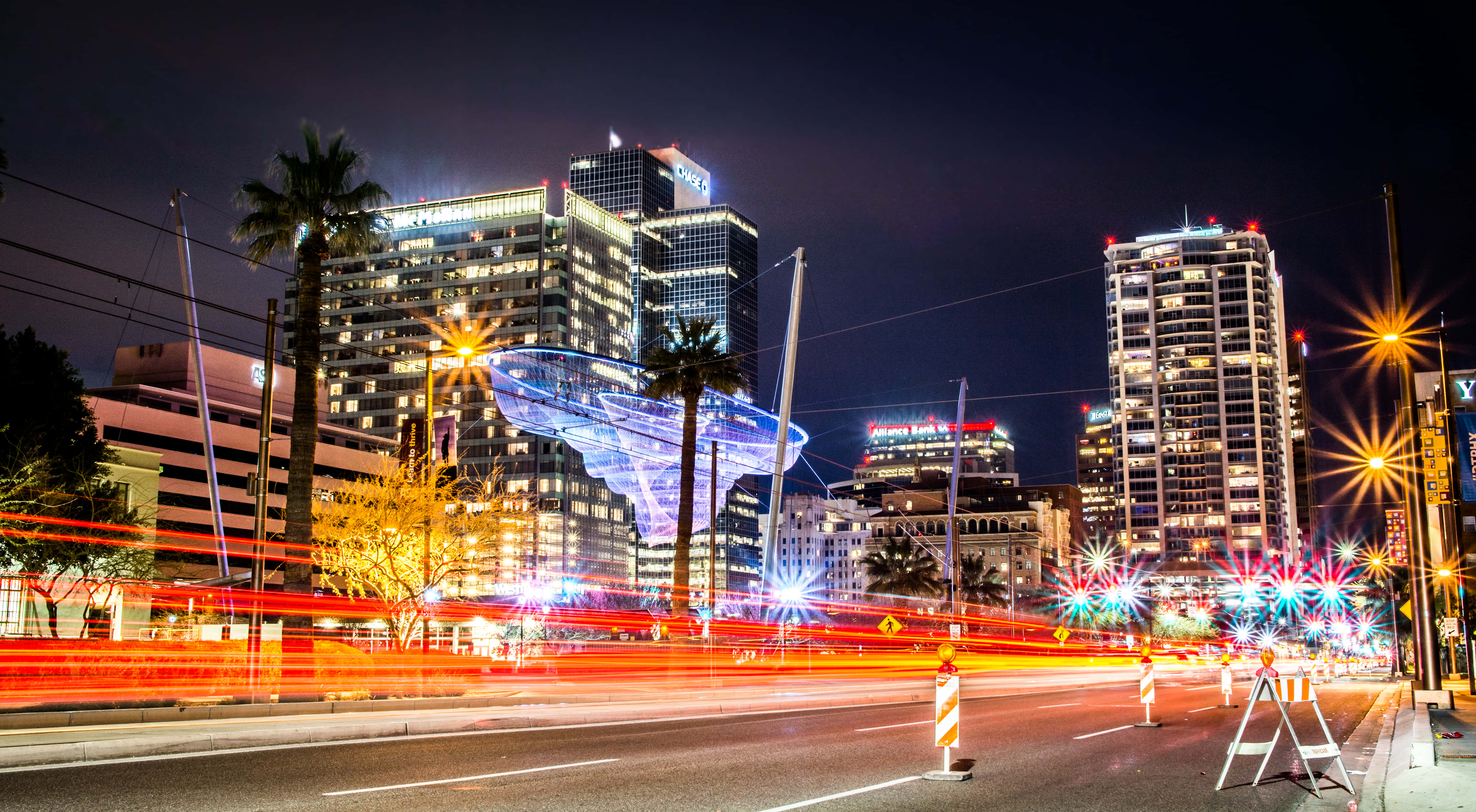 Phoenix Arizona 桌布 壁紙 — 在黑暗天空下，充滿活力的夜景，帶有流動的交通燈光和明亮的摩天大樓。