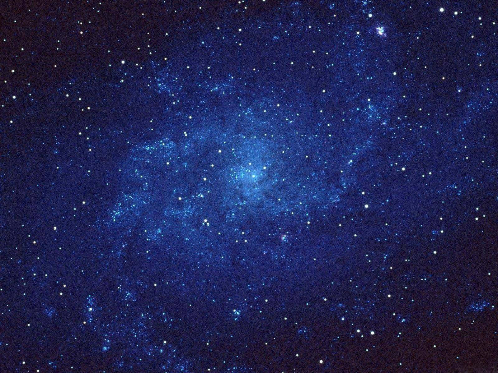 Starry Sky 桌布 壁紙 — 在黑暗宇宙背景下，深藍色星雲閃爍著散落星光的壯麗景色。