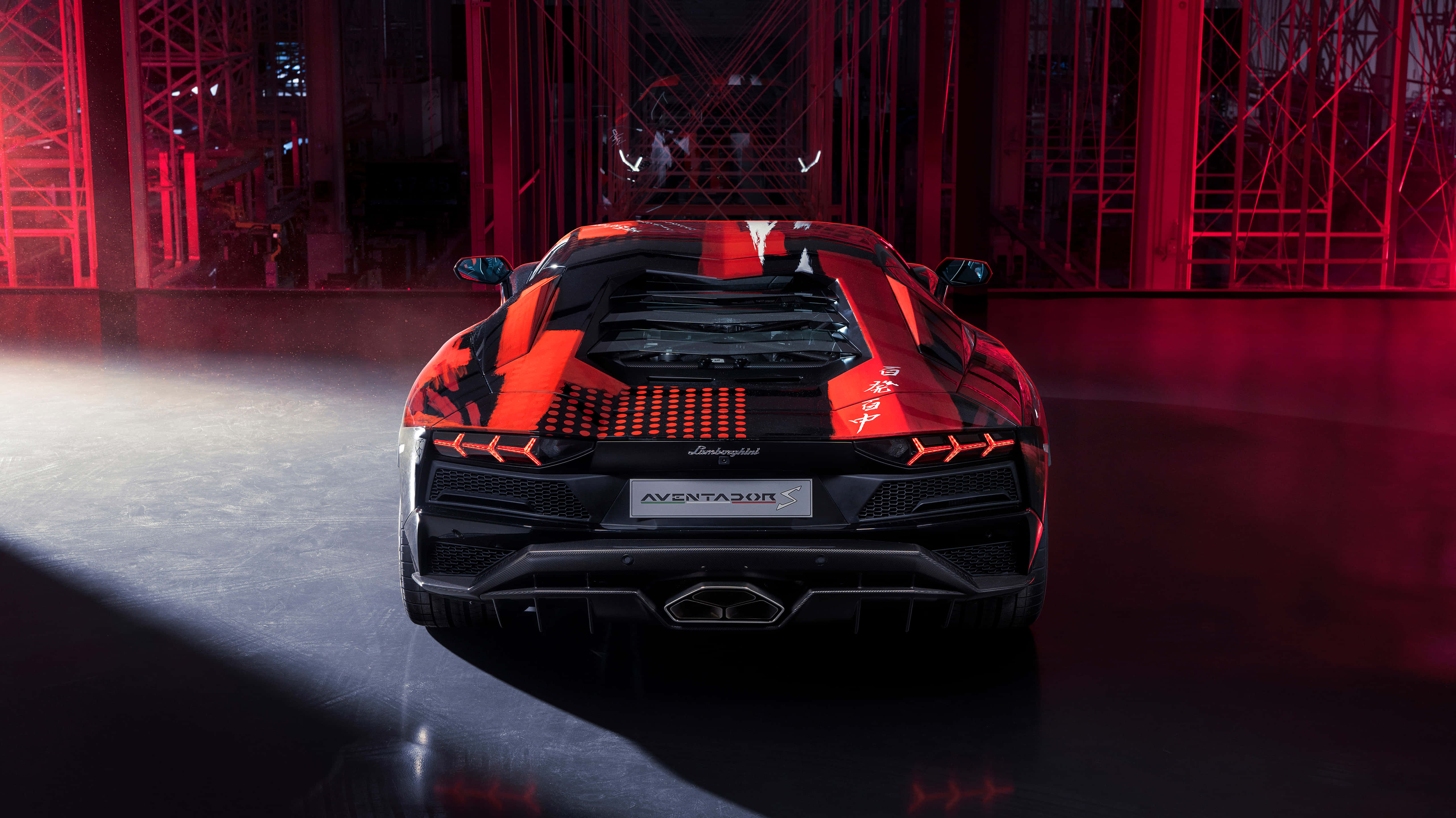 黑色 桌布 壁紙 — 在黑暗工業環境中，紅色和黑色的藍寶堅尼 Aventador SVJ 在戲劇性的紅色燈光下的後視圖。