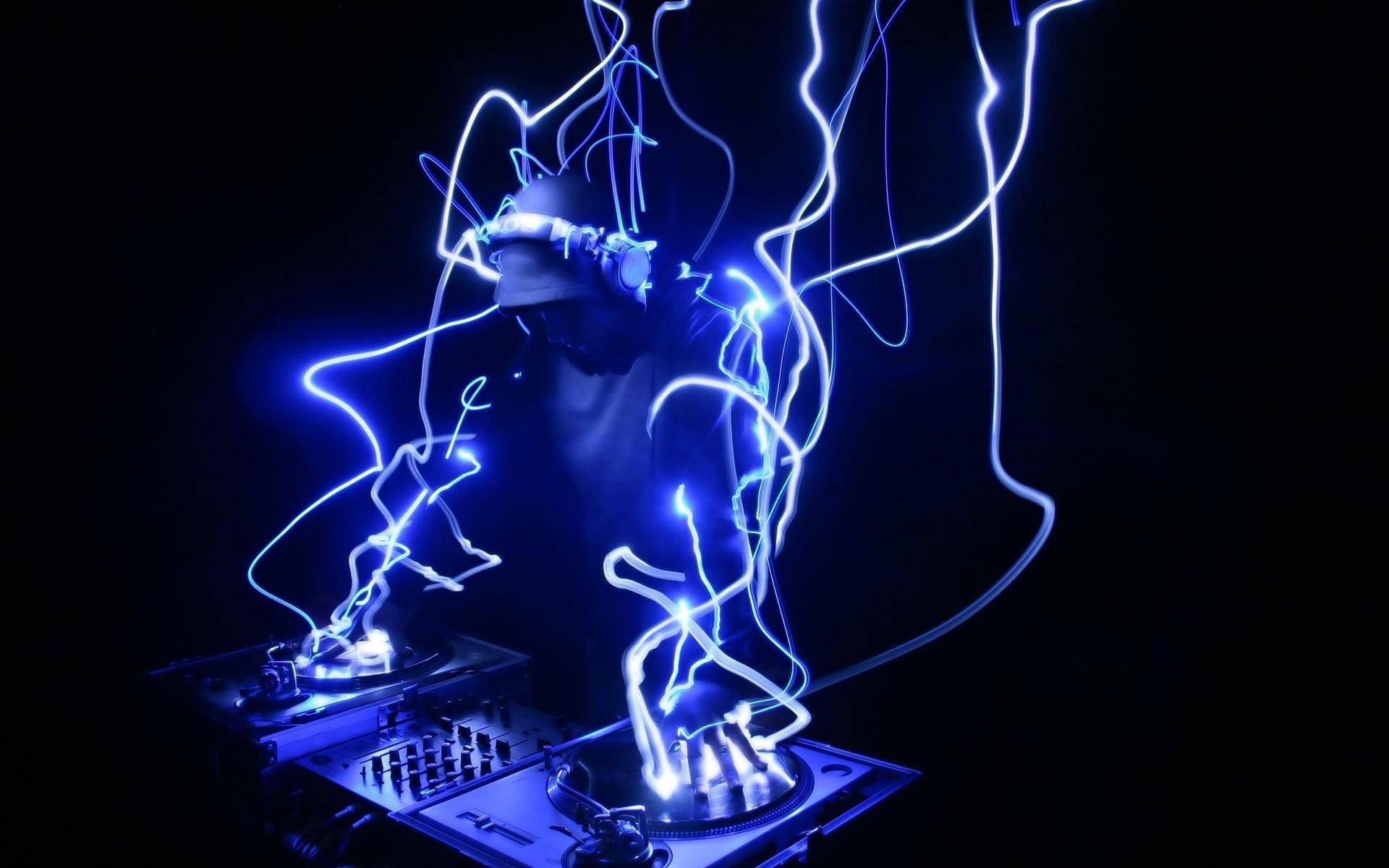 電力 桌布 壁紙 — 在黑暗的俱樂部環境中，DJ 剪影沐浴在圍繞唱盤舞動的電光藍色光跡中。
