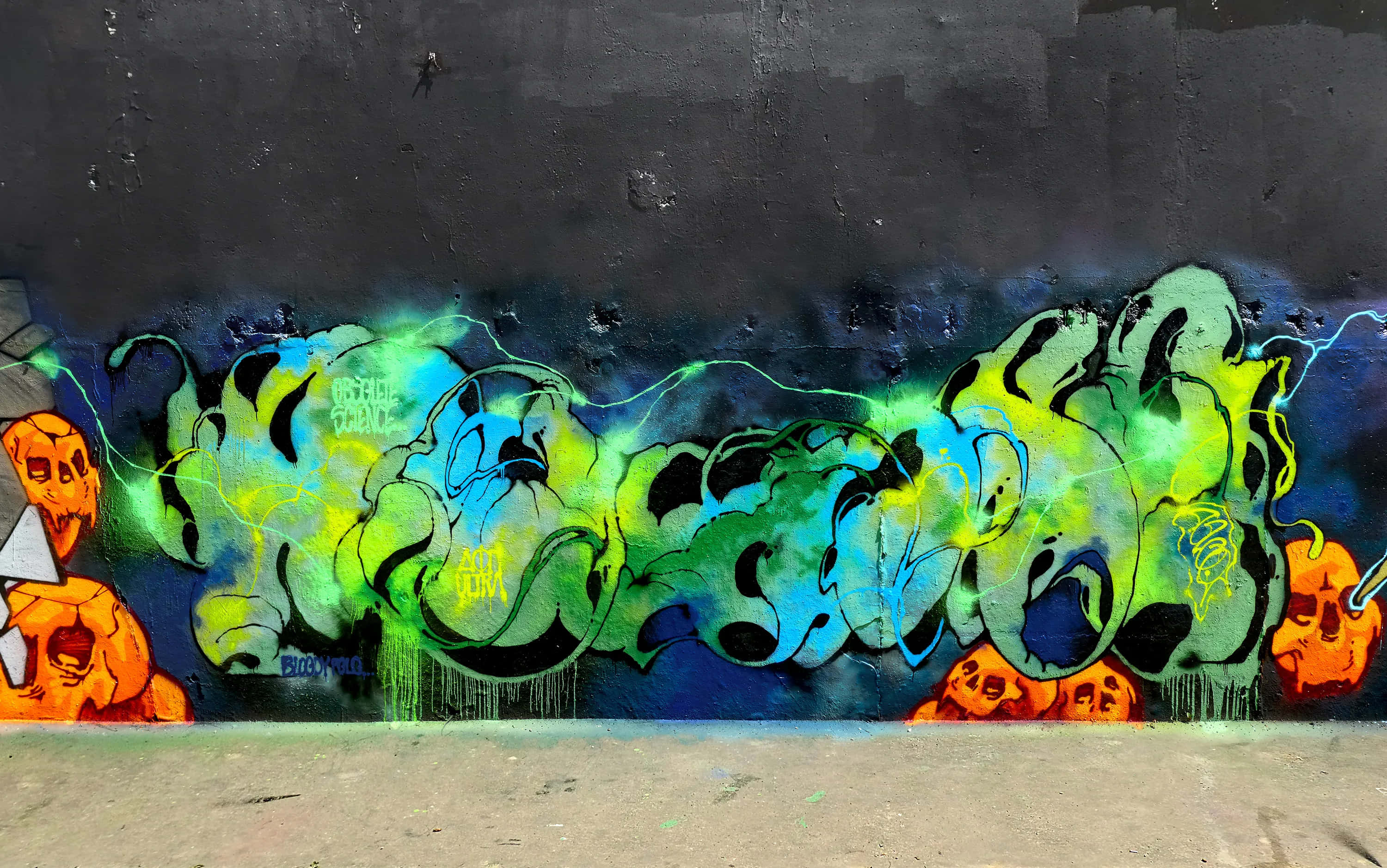 Graffiti Art 桌布 壁紙 — 在黑暗的城市牆上噴塗充滿活力的螢光綠色和藍色塗鴉標籤，帶有橙色骷髏圖案。