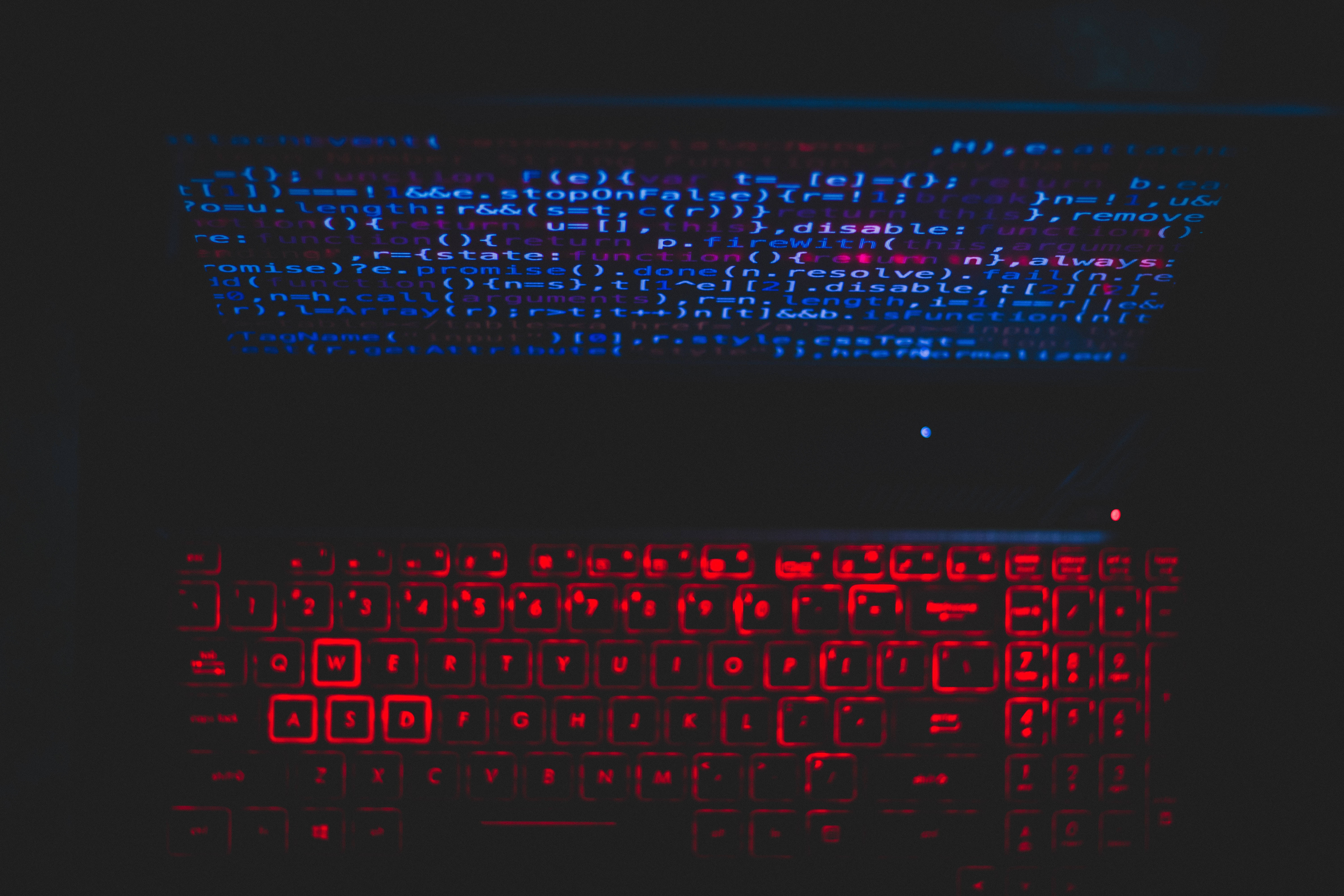 Computer Screen 桌布 壁紙 — 在黑暗的數位工作空間中，發光的紅色鍵盤與漂浮的藍色程式碼行。