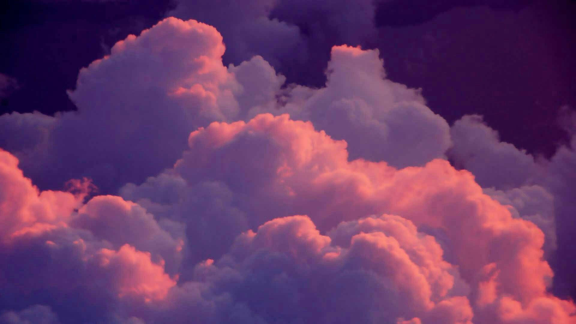 美學雲朵 桌布 壁紙 — 在黑暗的暮色天空中，豐盈的雲朵散發出火紅的粉紅色和深紫色的色調。