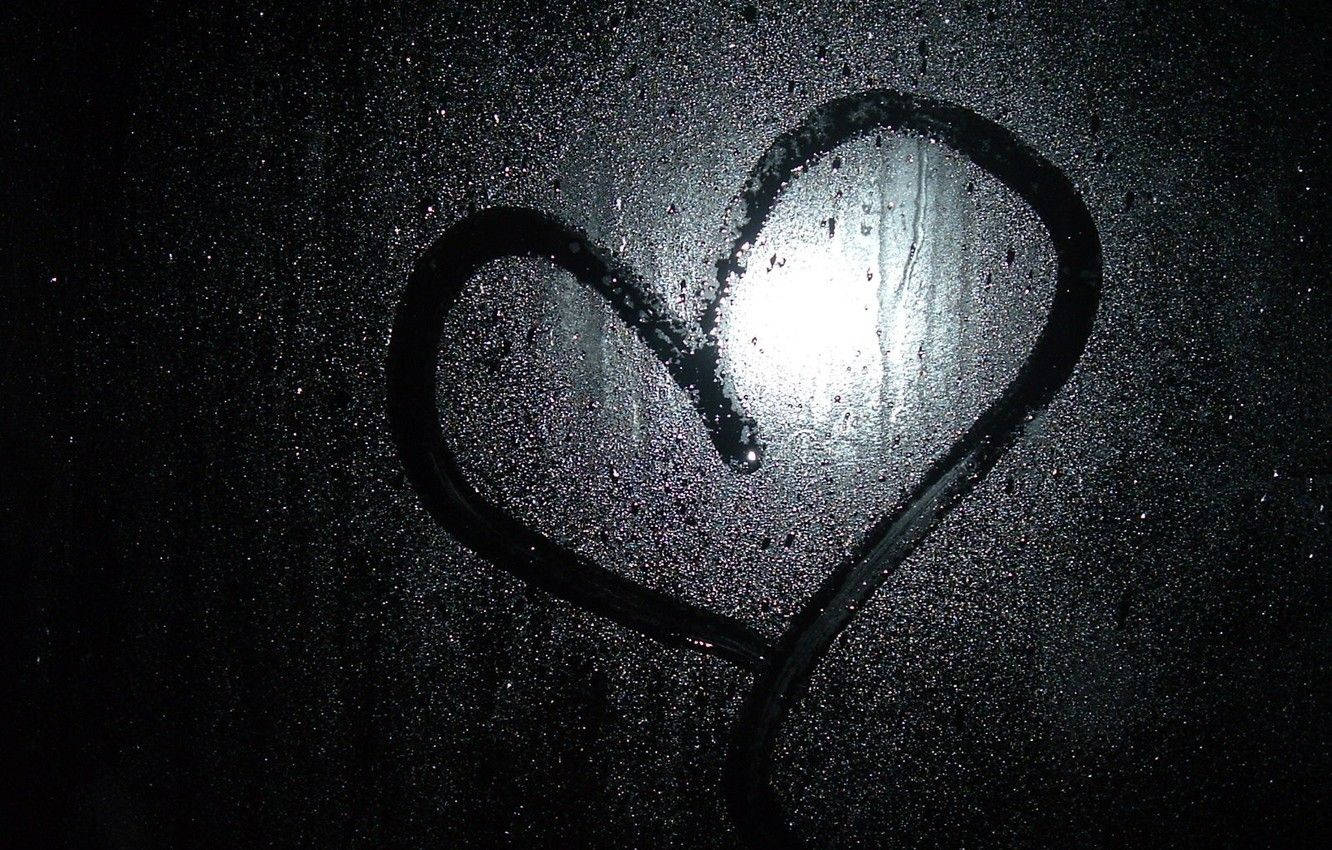 Dark Heart 桌布 壁紙 — 在黑暗的窗戶上，雨滴畫出一顆心，中央有明亮的光線穿透。
