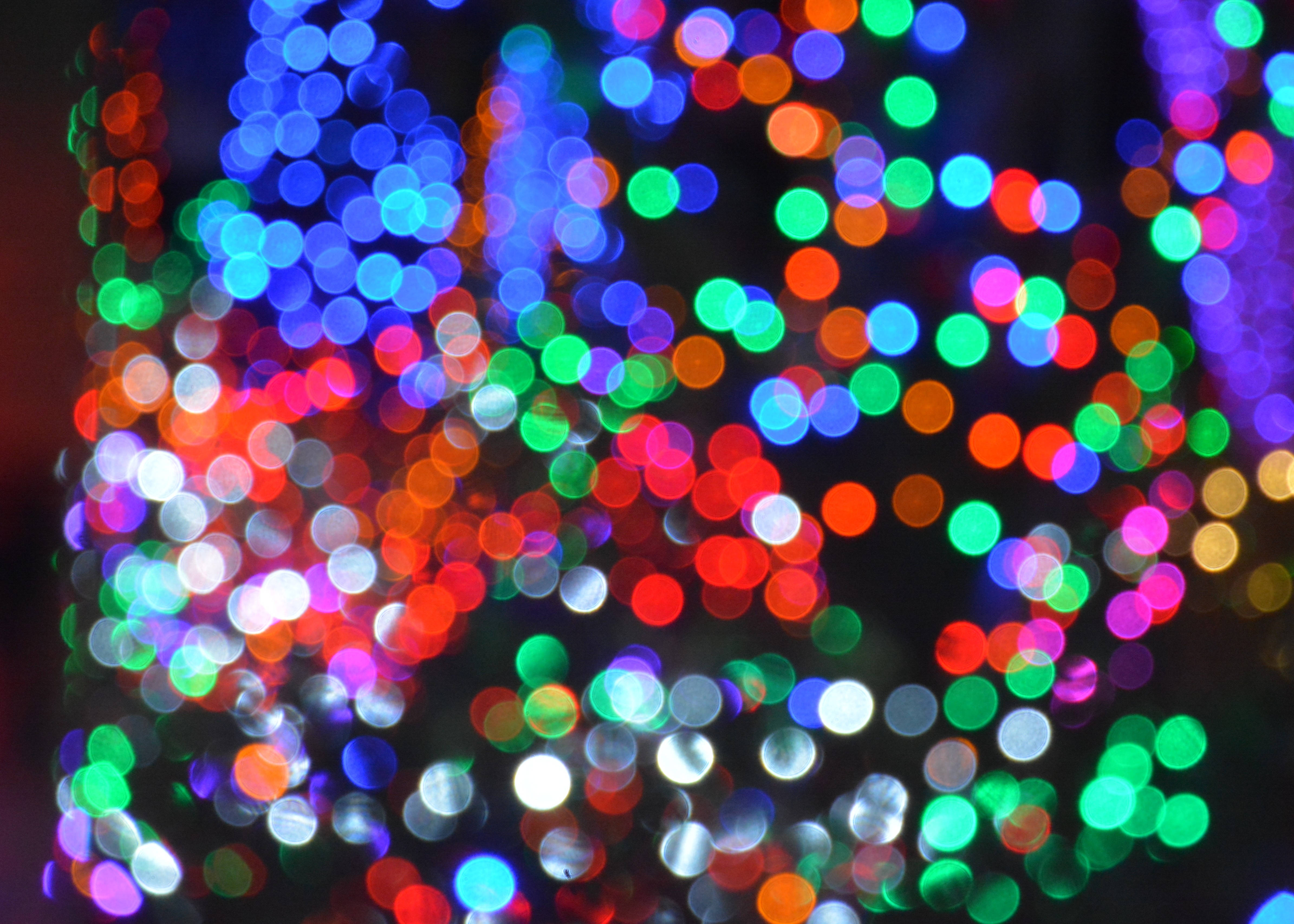 Bokeh 桌布 壁紙 — 在黑暗背景上發光的彩色圓形燈光形成充滿活力的散景。