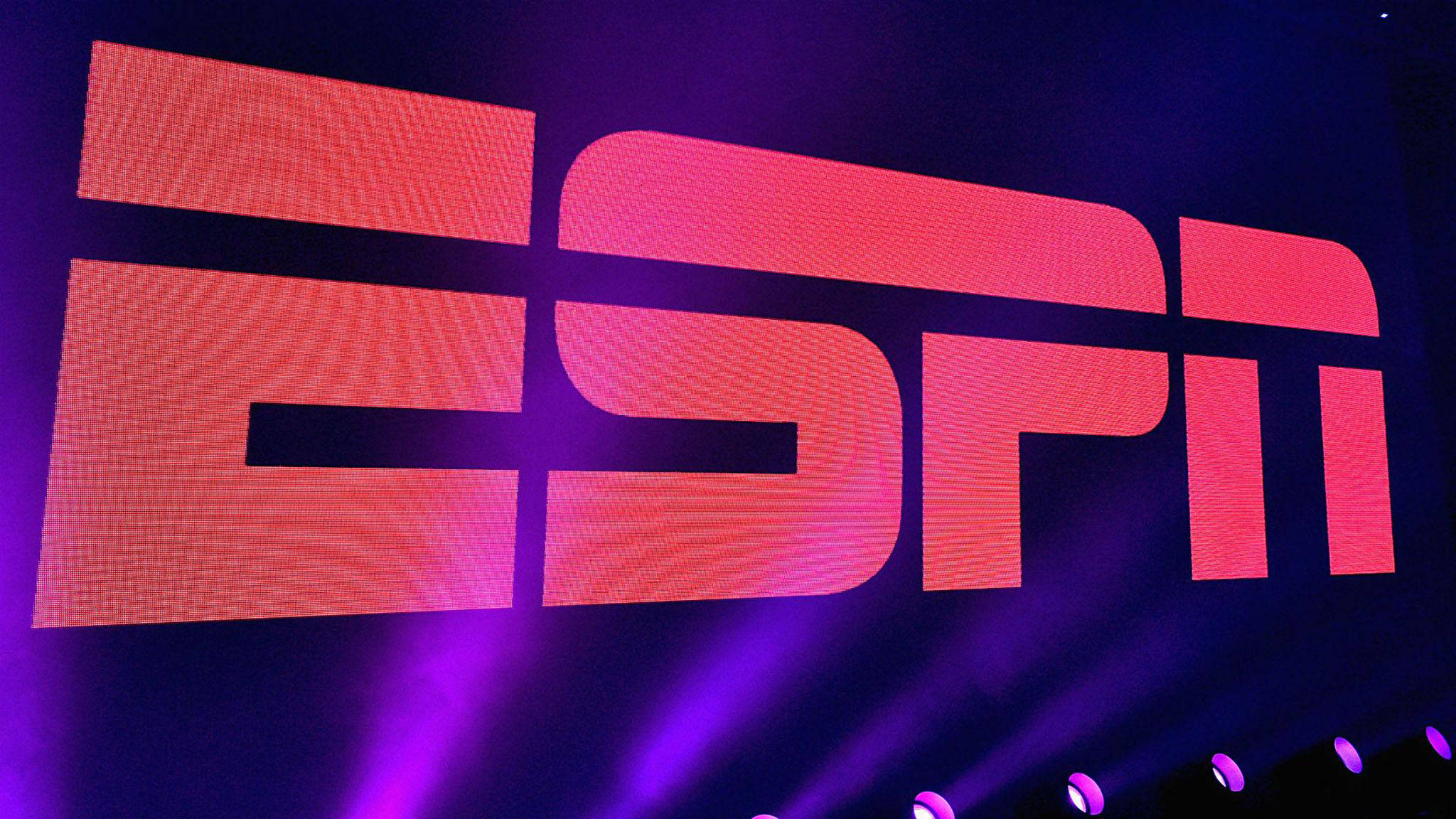 Espn 桌布 壁紙 — 在黑暗背景下，紫色舞台燈光照射下，ESPN標誌呈現鮮豔的紅色和粉紅色光芒。