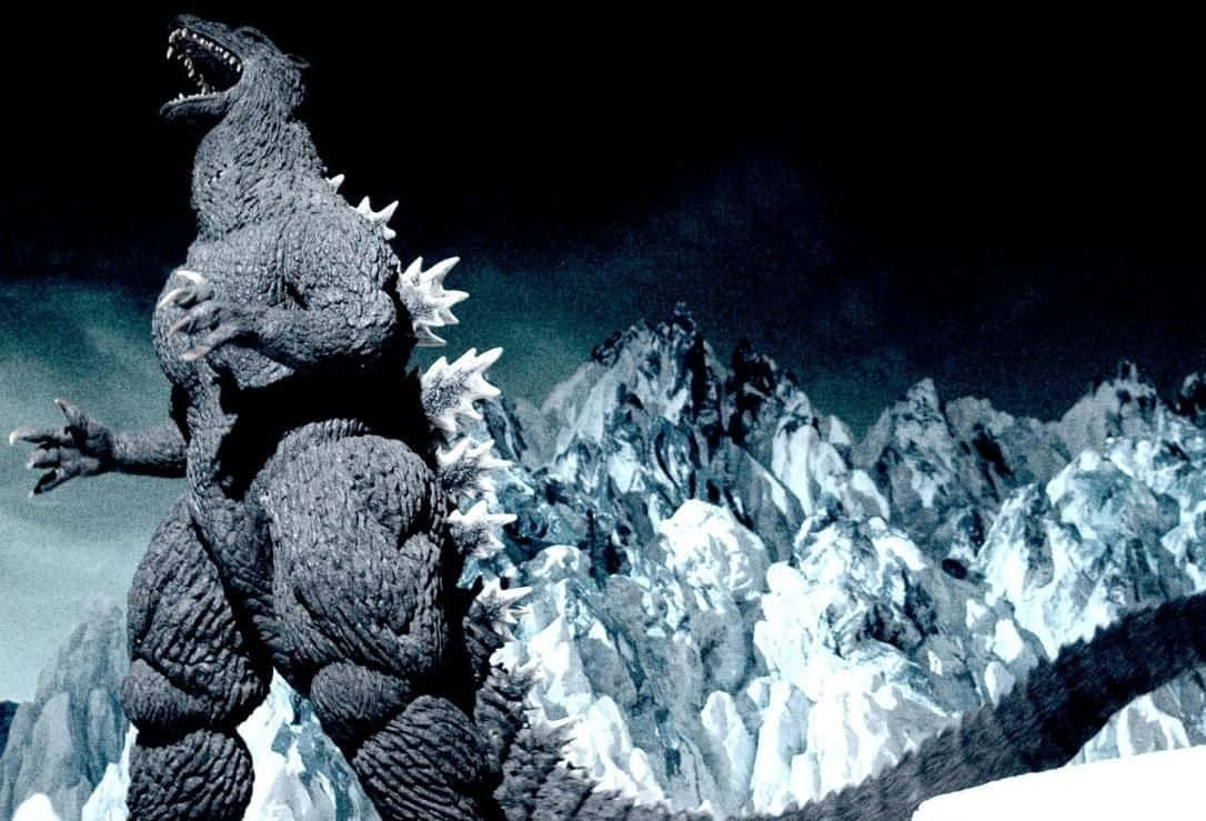 Godzilla 1954 桌布 壁紙 — 在黑暗風暴的天空下，高聳的哥吉拉在積雪的山頂上咆哮。