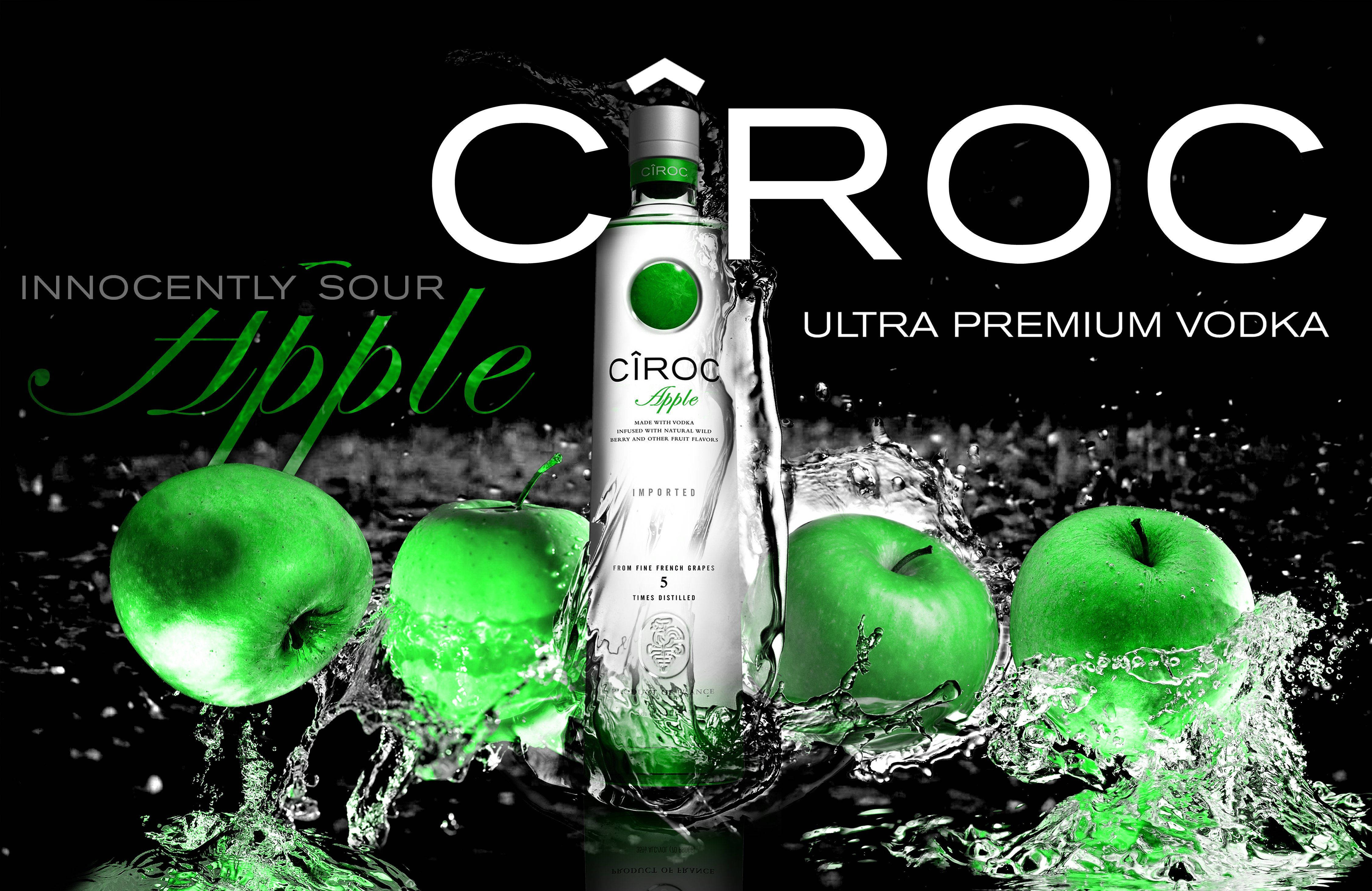 Drink 桌布 壁紙 — 在黑色背景下，一瓶時尚的Ciroc Apple伏特加被鮮綠色的蘋果和飛濺的水花環繞。