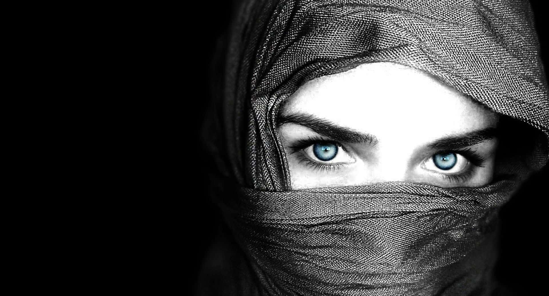 Black Is Beautiful 桌布 壁紙 — 在黑色背景下，女性強烈的藍色眼睛穿透深色紋理面紗。