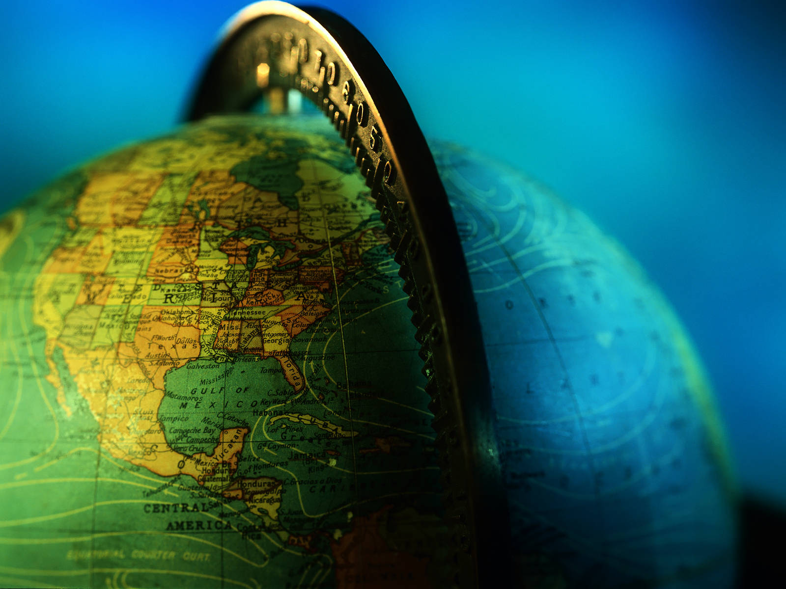 World Globe 桌布 壁紙 — 地球儀的特寫，邊緣放著一枚硬幣，背景為藍色漸層。
