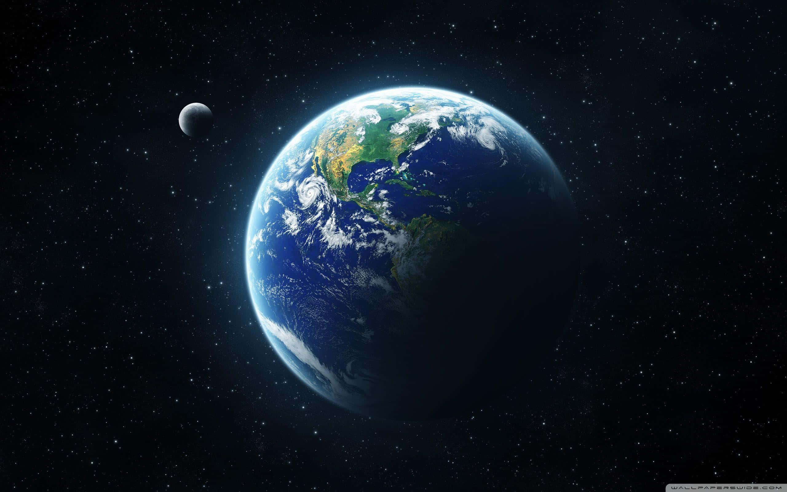 桌布 壁紙 — 地球在太空中發出藍色和綠色的光芒，周圍有月球和星星。