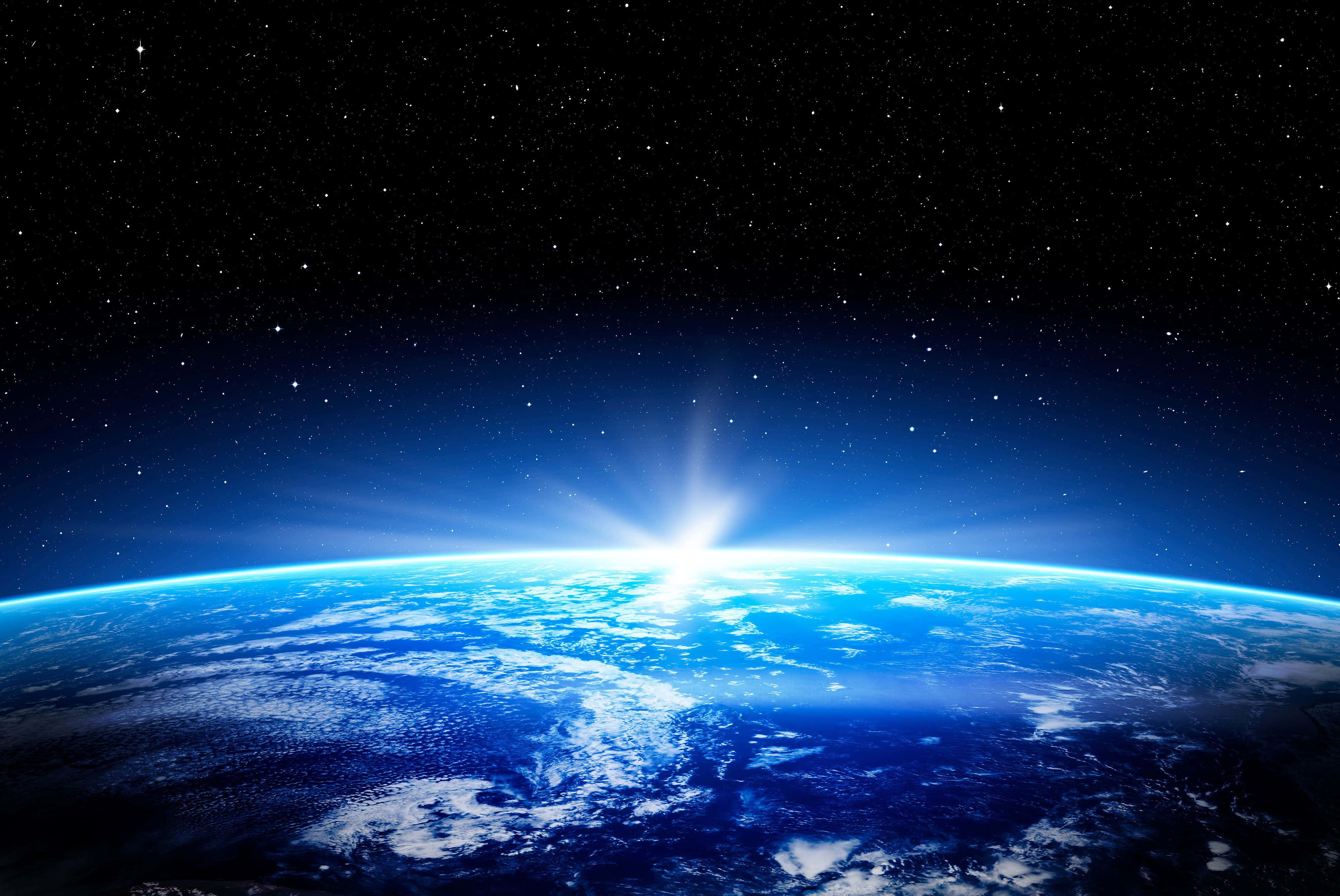 World 桌布 壁紙 — 地球在燦爛的日出中升起，背景是繁星點點的黑色天空，藍色海洋閃耀，白雲飄浮。