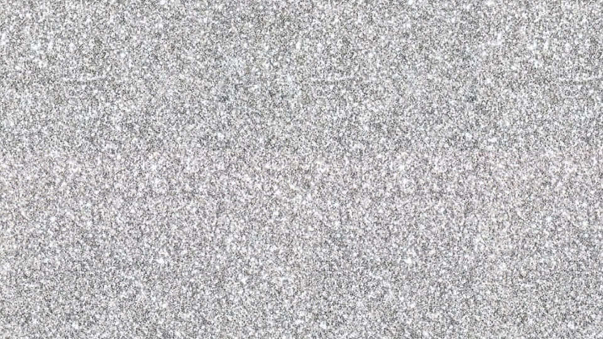 High Resolution Glitter 桌布 壁紙 — 均勻光線下光滑灰色花崗岩表面的特寫，帶有白色和黑色礦物顆粒斑點。