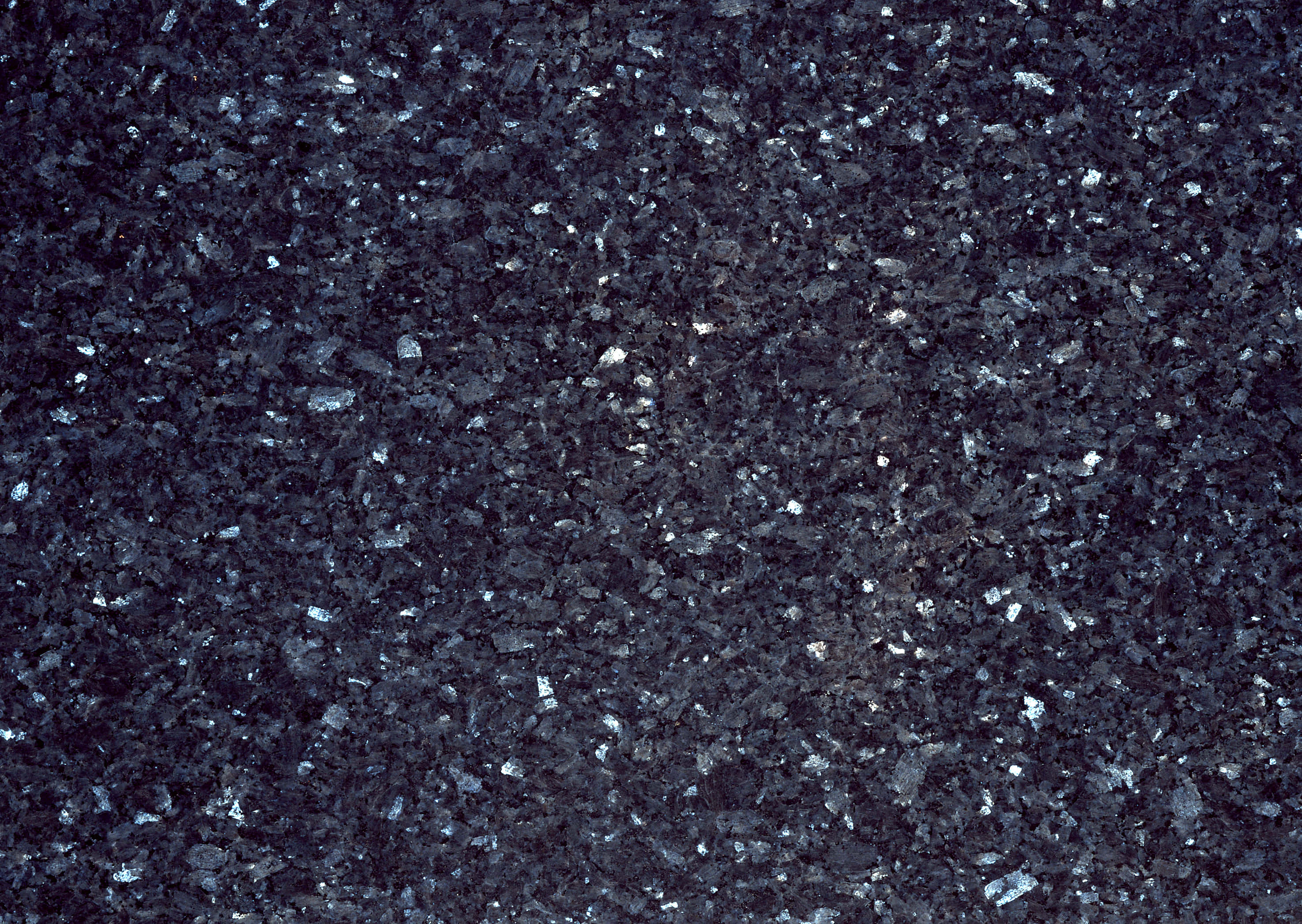 Granite 桌布 壁紙 — 均勻光線下深色斑點花崗岩的特寫，帶有閃爍的白色斑點。