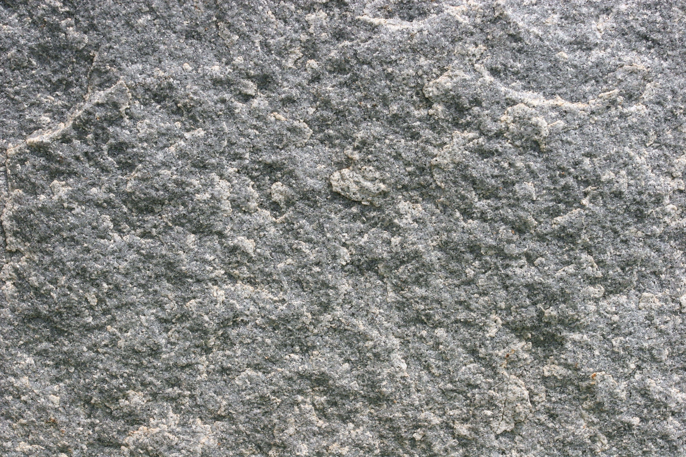 Stone 桌布 壁紙 — 均勻光線下粗糙灰色花崗岩表面的特寫，帶有白色和黑色斑點礦物顆粒。