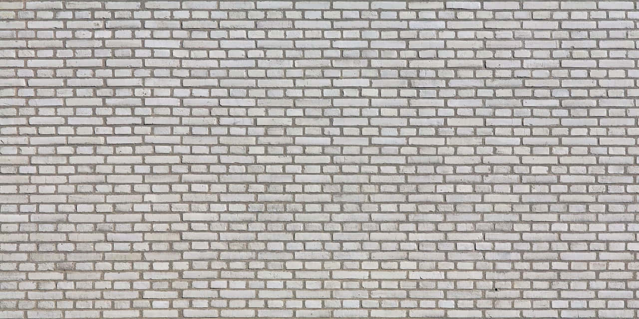 wall 桌布 壁紙 — 均勻照明下，乾淨白色磚牆的特寫，帶有細微紋理和砂漿線。