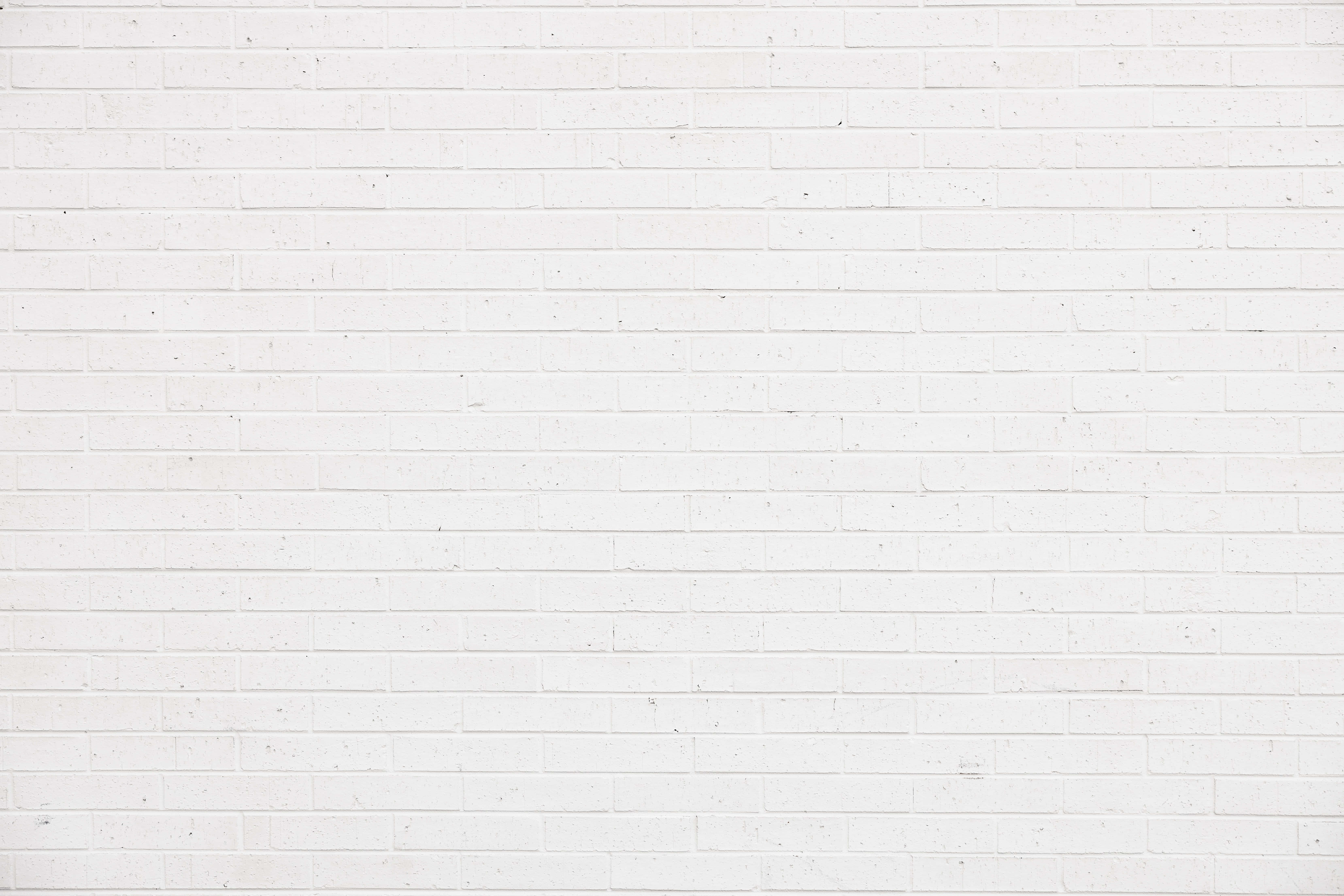 White Brick Wall 桌布 壁紙 — 均勻照明下，帶有細微紋理和砂漿線的清潔白色磚牆。