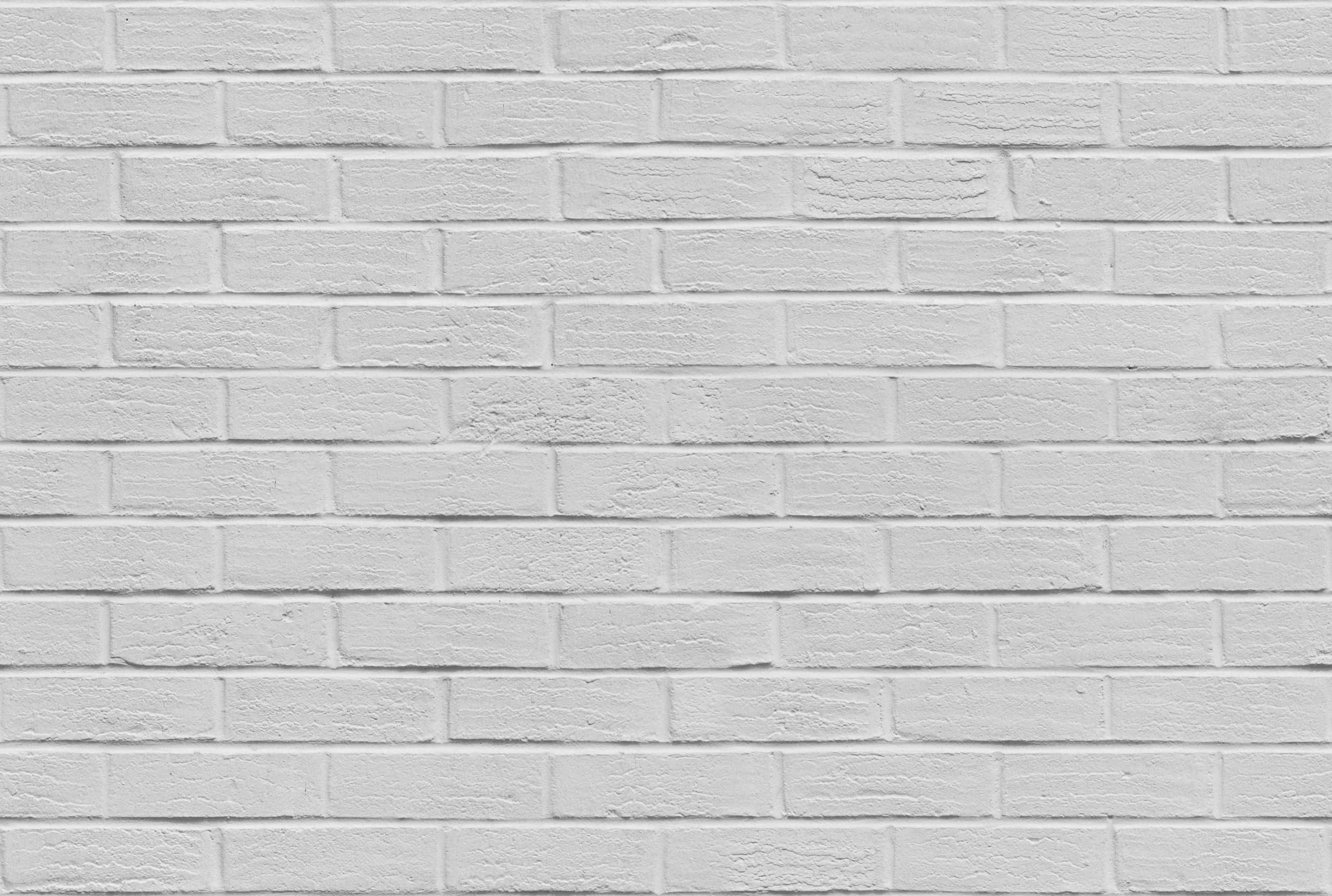 White Wall 桌布 壁紙 — 均勻照明下，帶有細微紋理和砂漿線的清潔白色磚牆。
