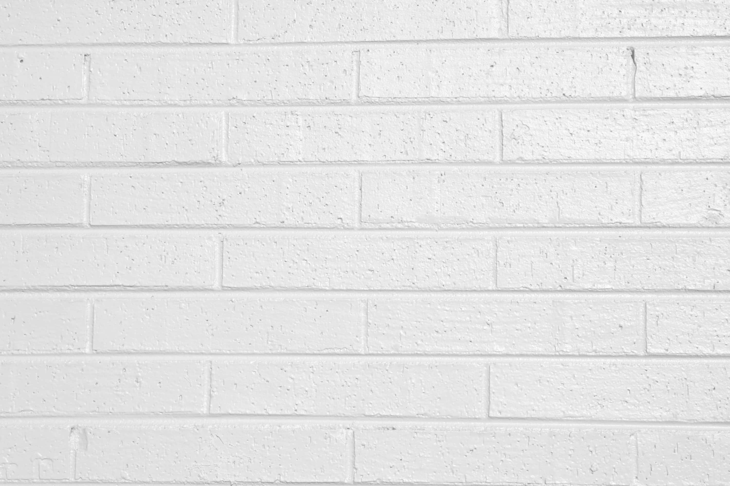 White Brick Wall 桌布 壁紙 — 均勻照明下，帶有細微紋理和砂漿線的清潔白色磚牆。