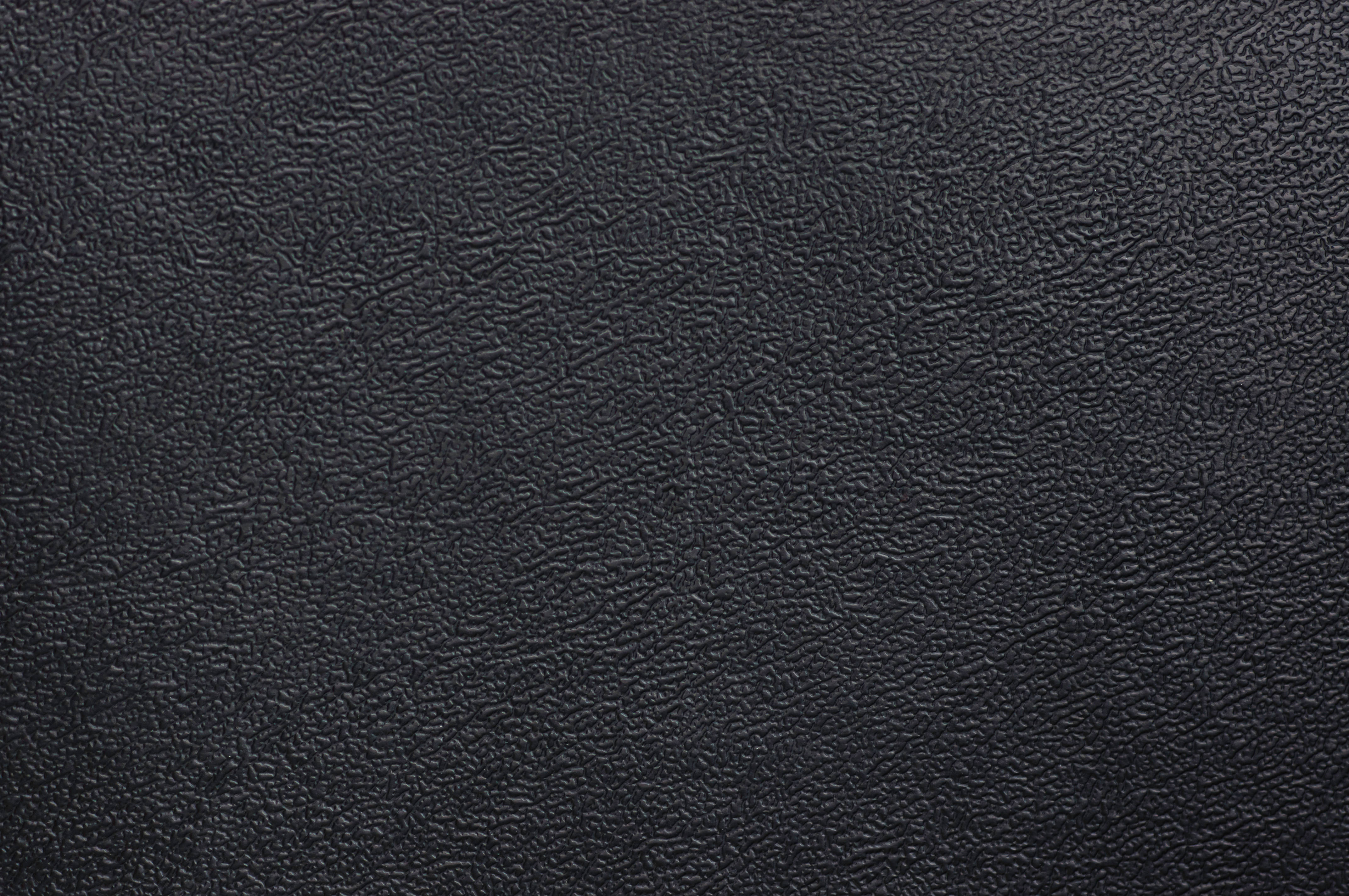 Textured 桌布 壁紙 — 均勻照明下光滑黑色皮革表面的特寫，帶有細粒紋理。