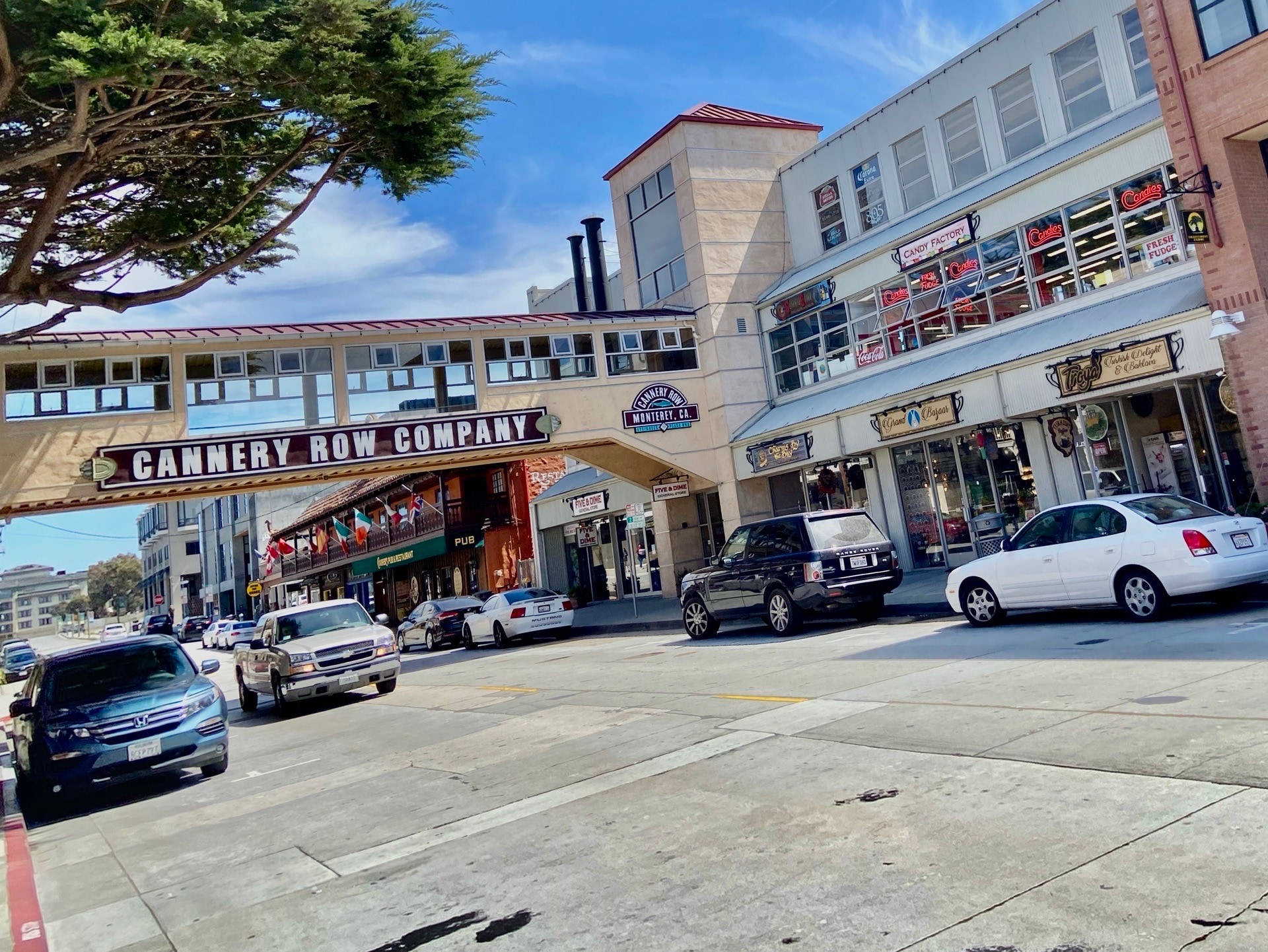 加州 桌布 壁紙 — 坎納利街的陽光街道場景，汽車沿著商店停放，藍天白雲。