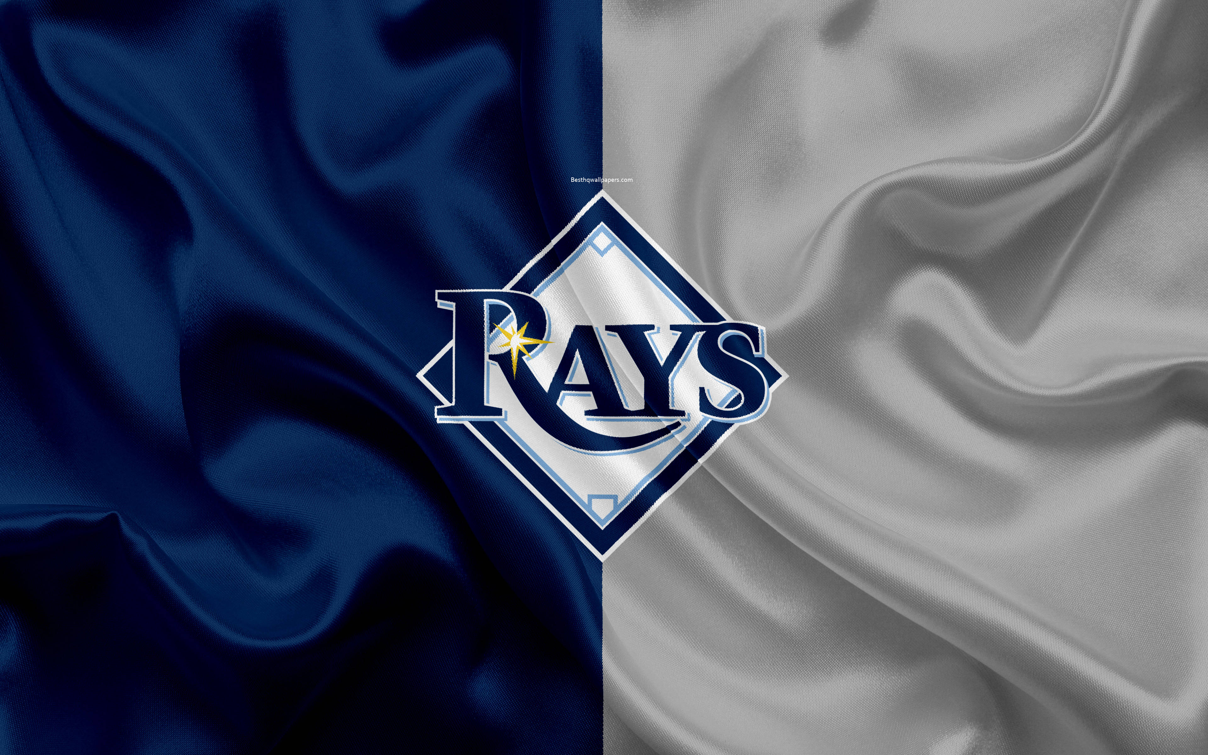 Rays 桌布 壁紙 — 坦帕灣光芒隊標誌居中，置於分為藍色和銀色的緞面布料背景上，帶有流暢的褶皺。
