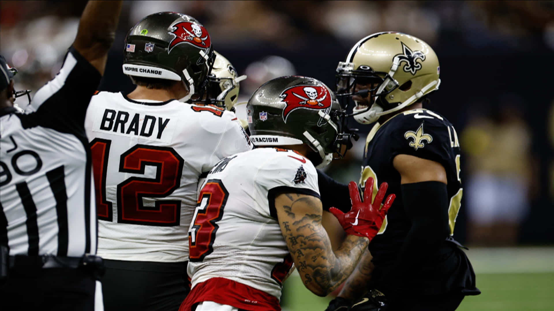 New Orleans Saints 桌布 壁紙 — 坦帕灣海盜隊球員與湯姆·布雷迪（12號）慶祝，而新奧爾良聖徒隊球員在足球場上與他們對峙。
