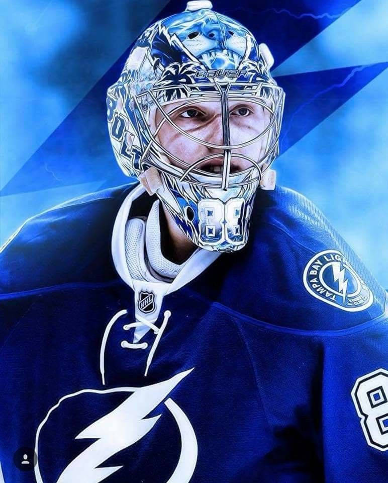 hockey 桌布 壁紙 — 坦帕灣閃電隊冰球守門員的近距離特寫，身穿藍色球衣，號碼88，戴著精緻的銀藍色面罩，背景為動態藍色。