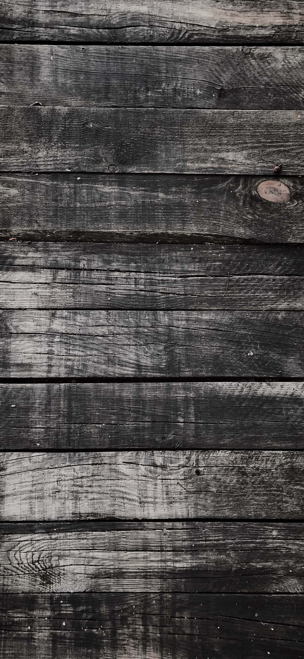 Black Wood 桌布 壁紙 — 垂直特寫風化深灰色木板，顯示木紋、節疤和自然質感。