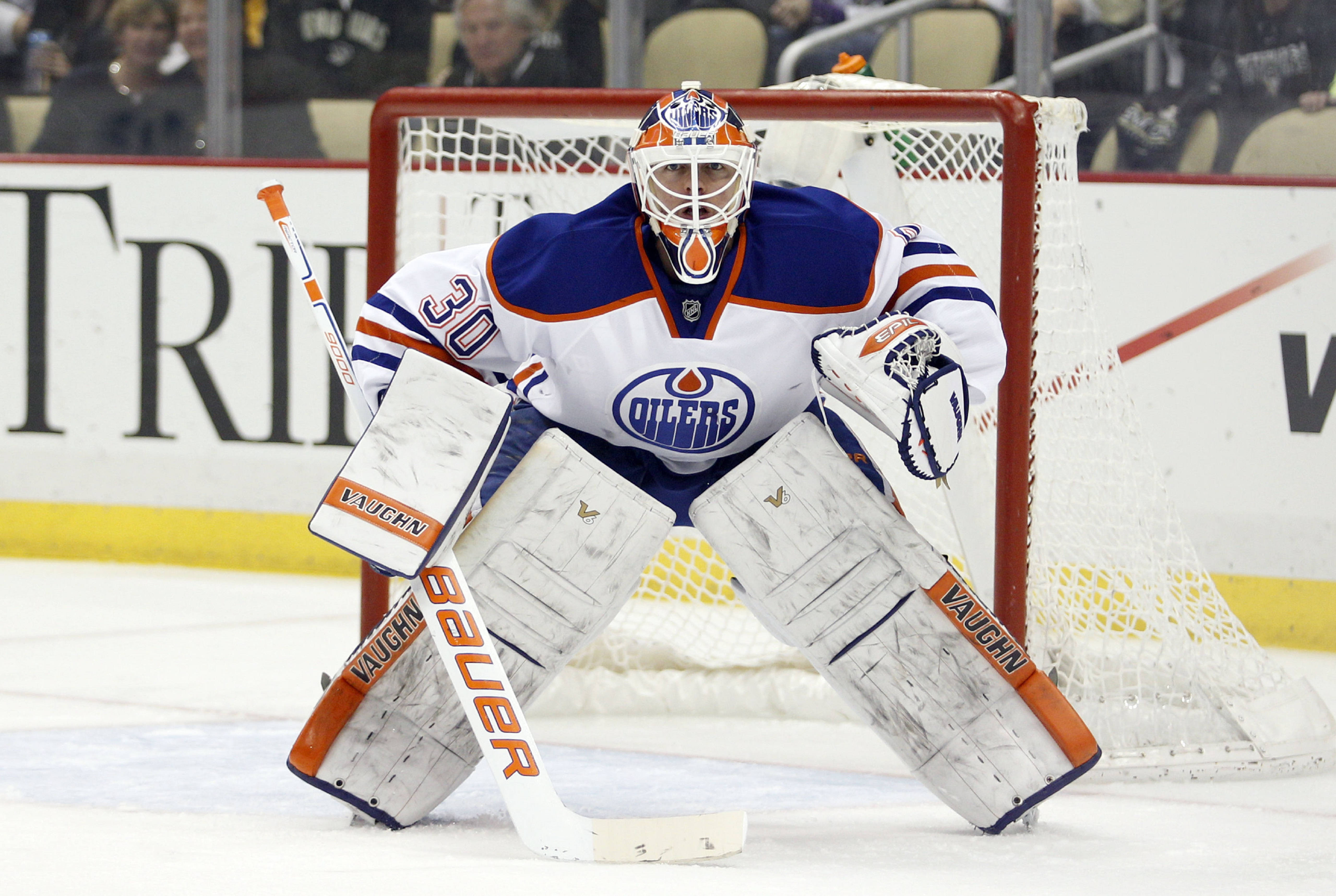 Oilers 桌布 壁紙 — 埃德蒙頓油人冰球守門員全副裝備在比賽中低蹲在球網前。