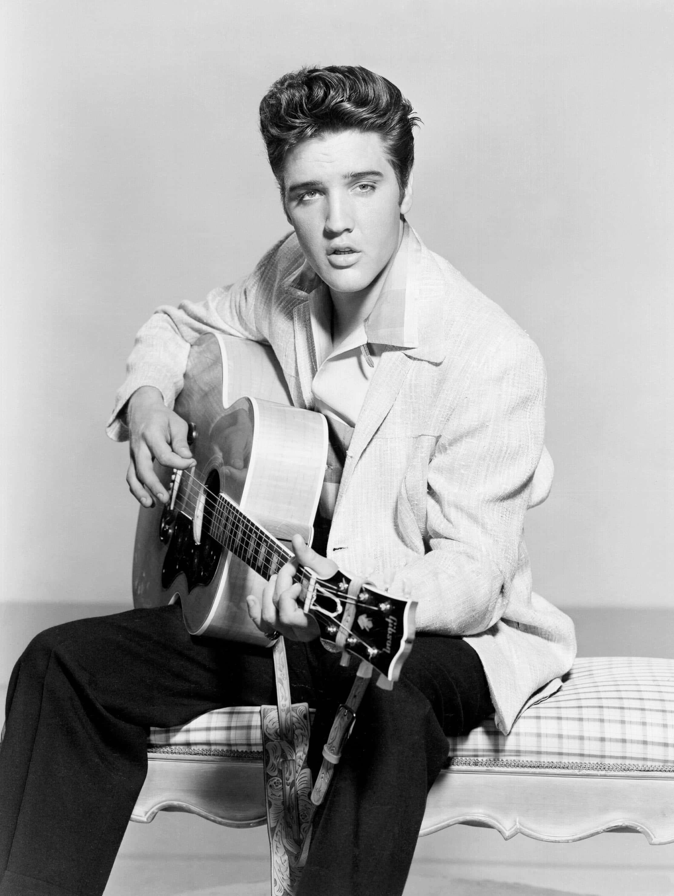 Elvis 桌布 壁紙 — 埃爾維斯·普雷斯利手持木吉他，在經典黑白工作室肖像中擺好姿勢。