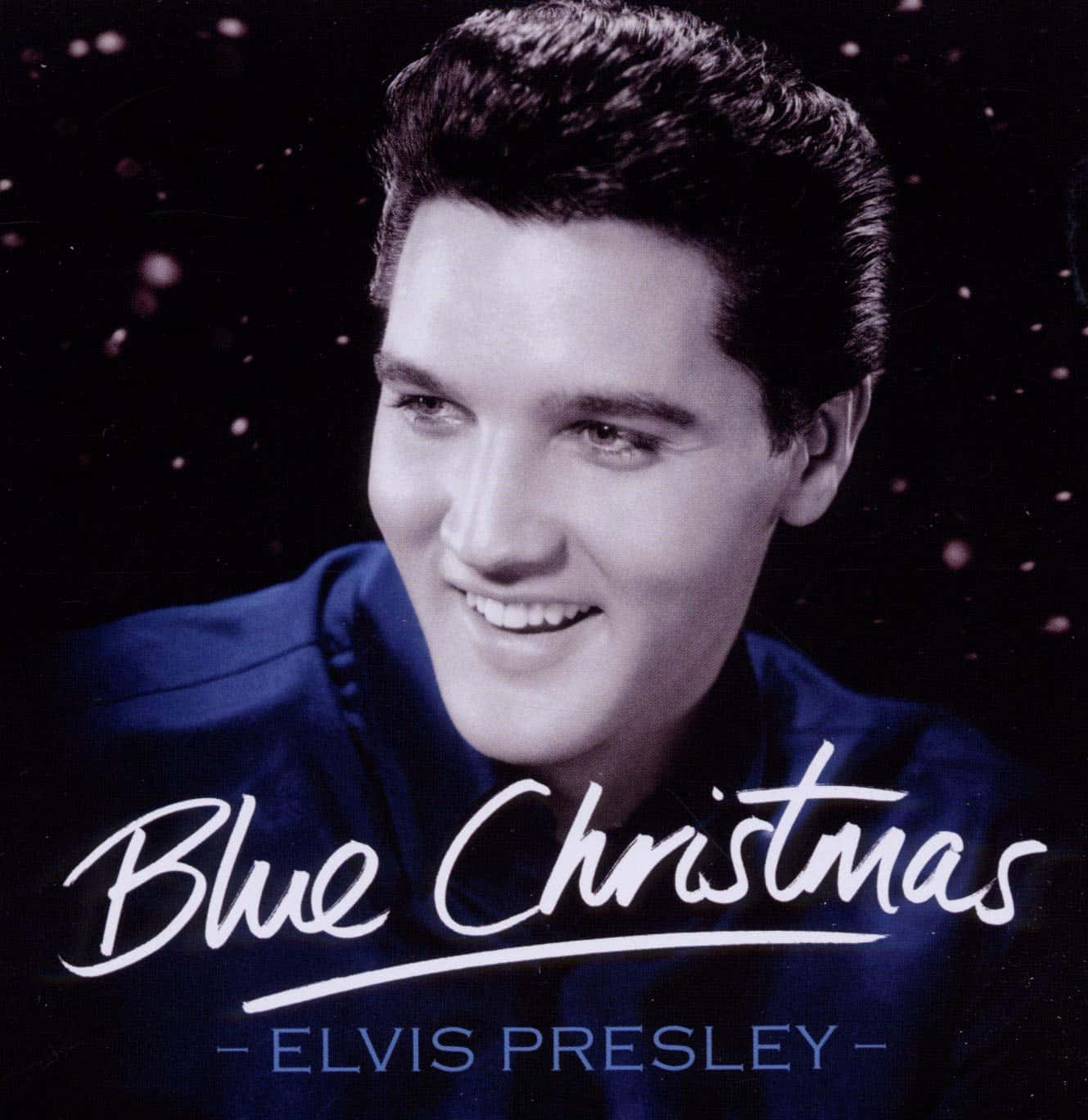 Elvis 桌布 壁紙 — 埃爾維斯·普雷斯利穿著藍色西裝，在黑暗背景中微笑，雪花飄落，並有「Blue Christmas」文字。