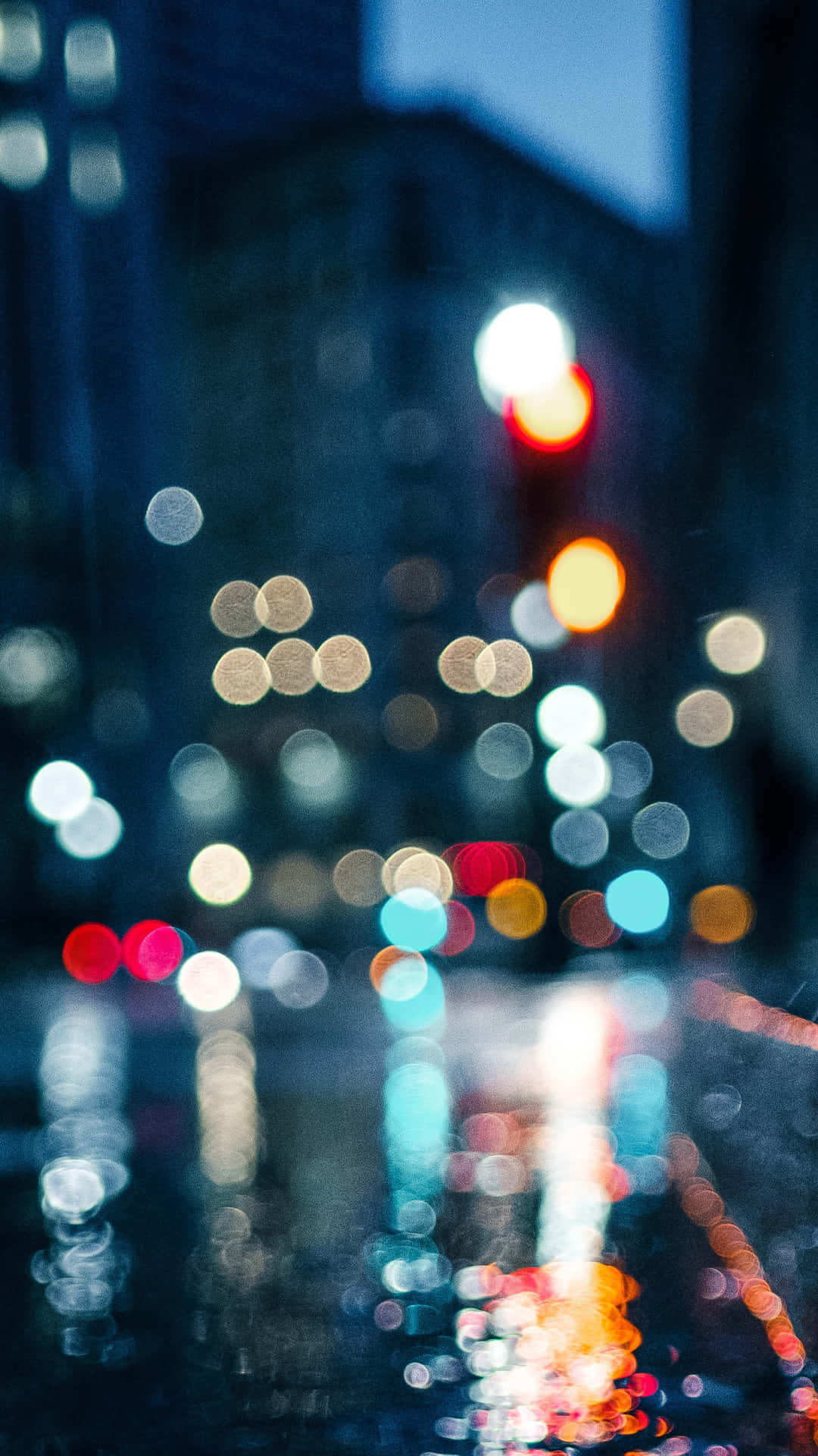 雨夜城市街道，模糊的燈光在濕漉漉的瀝青路面上反射。 — Google pixel 壁紙
