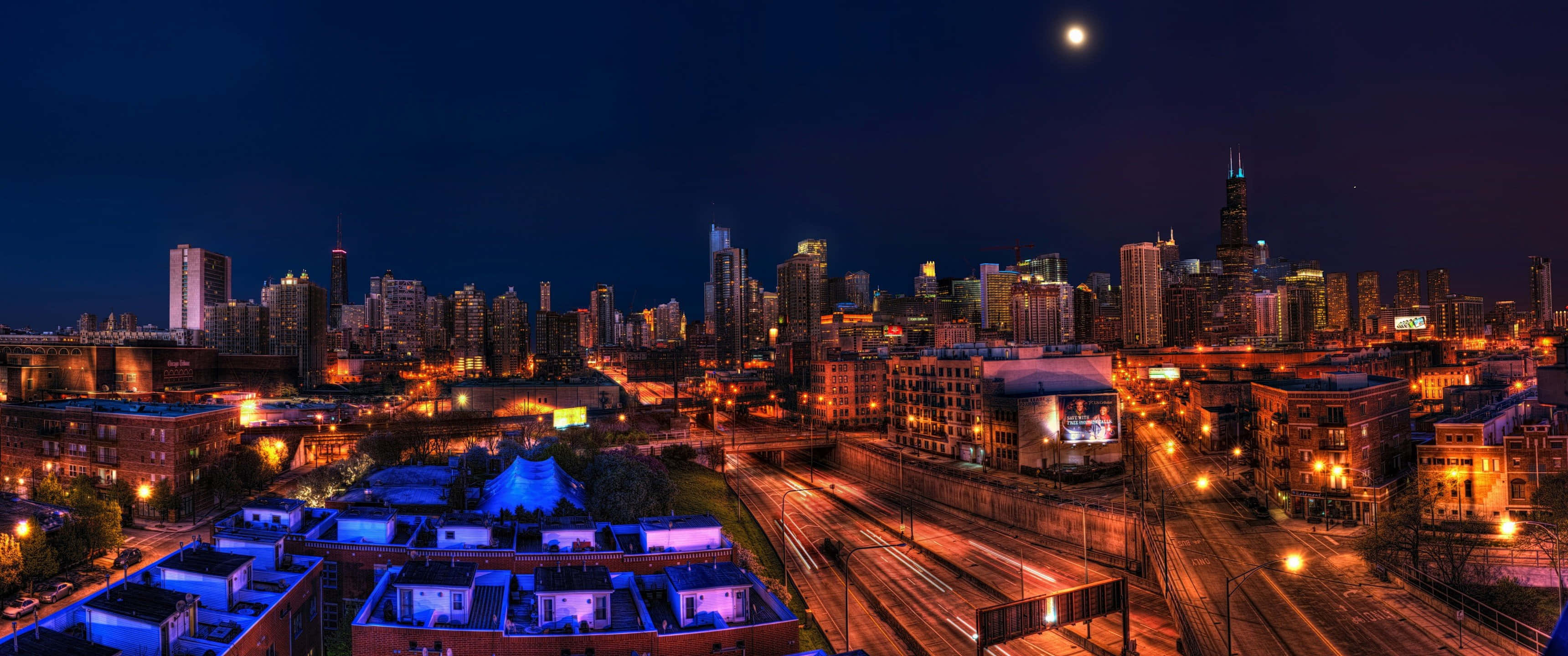 Ultra Wide 3440x1440 Space 桌布 壁紙 — 城市天際線的 panoramic 夜景，在明亮的月亮下閃爍的摩天大樓和街燈。