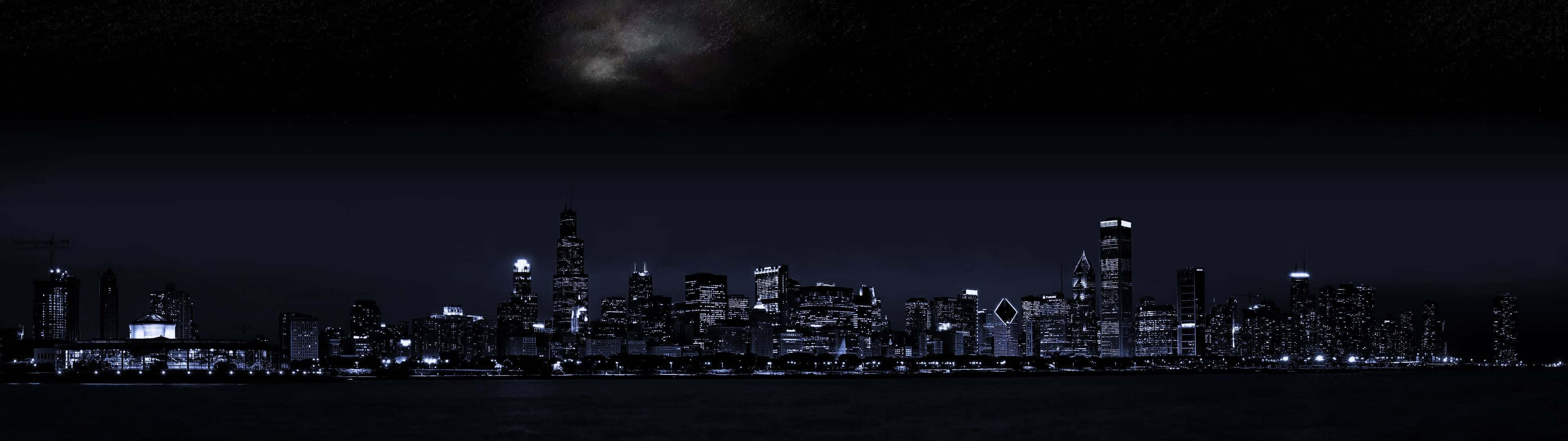 Building 桌布 壁紙 — 城市天際線的 panoramic 夜景，帶有發光的窗戶和繁星點點的天空。
