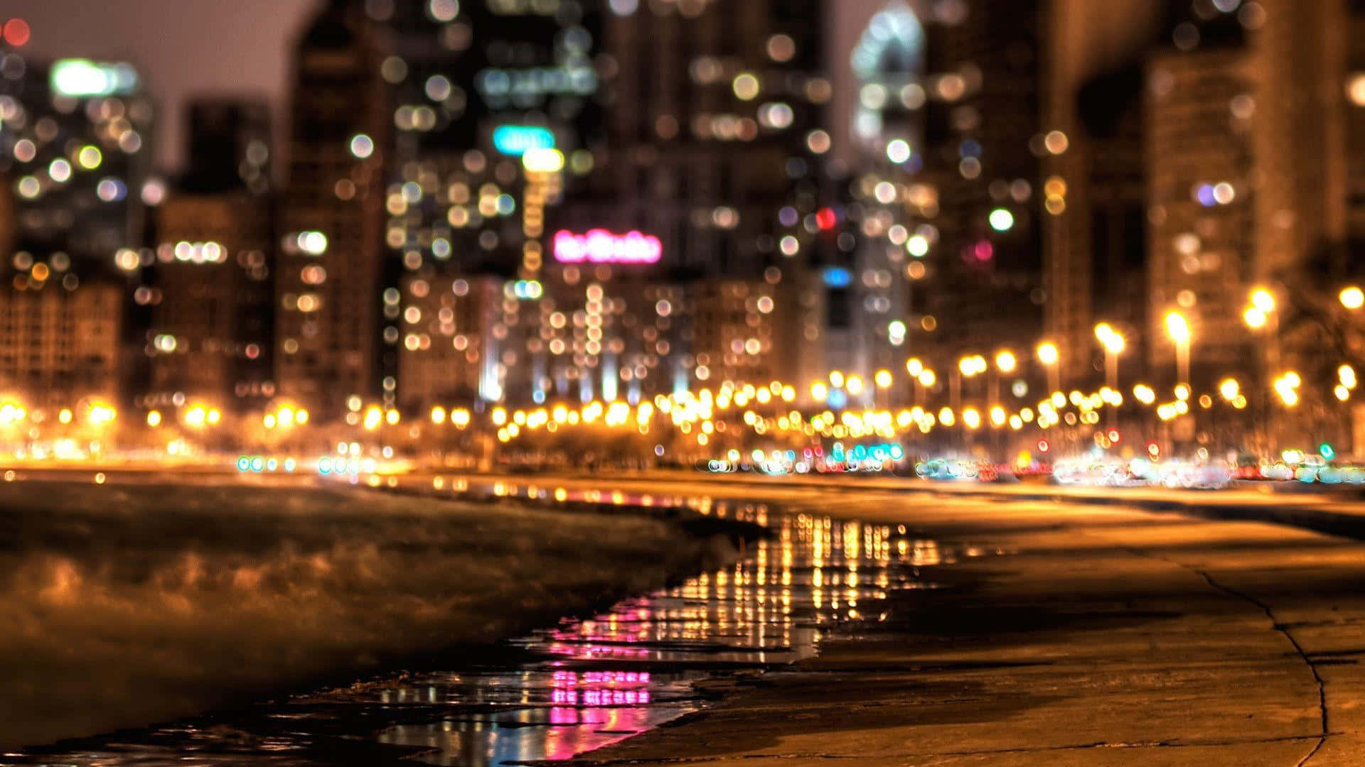 lights 桌布 壁紙 — 城市天際線的散景燈光在夜晚的濕漉漉路面上閃爍，營造出夢幻般的城市光輝。