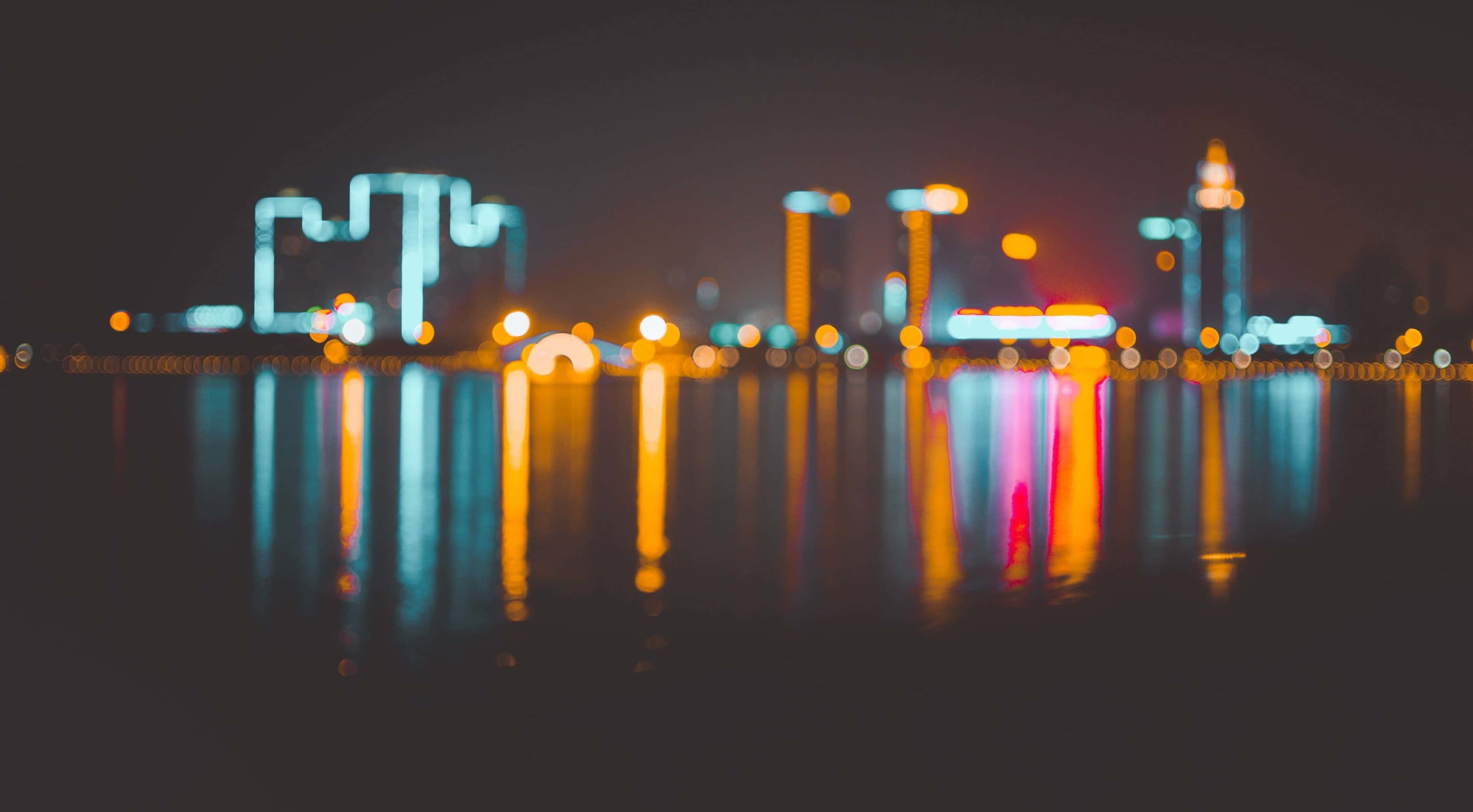 杜拜 桌布 壁紙 — 城市天際線的散景燈光在夜間在水面上閃爍，營造出夢幻般的城市倒影。