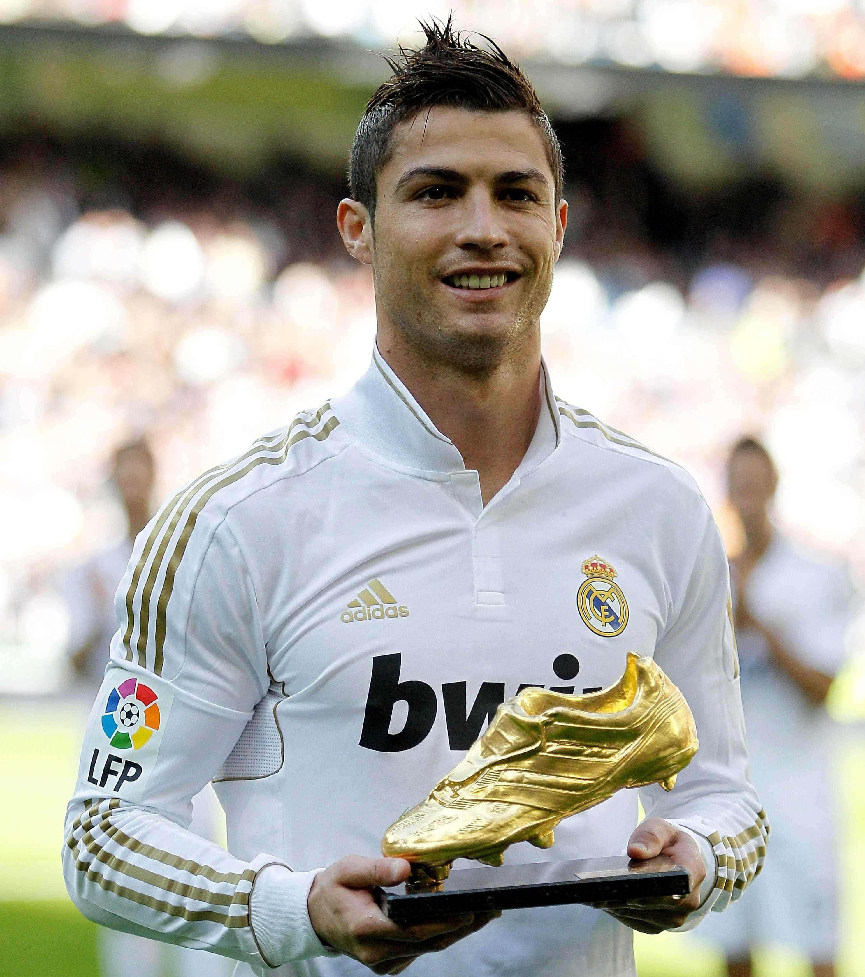 Ronaldo 桌布 壁紙 — 基斯坦奴·朗拿度在陽光明媚的球場上，自豪地微笑著，手持金色靴獎，身穿白色皇家馬德里球衣。