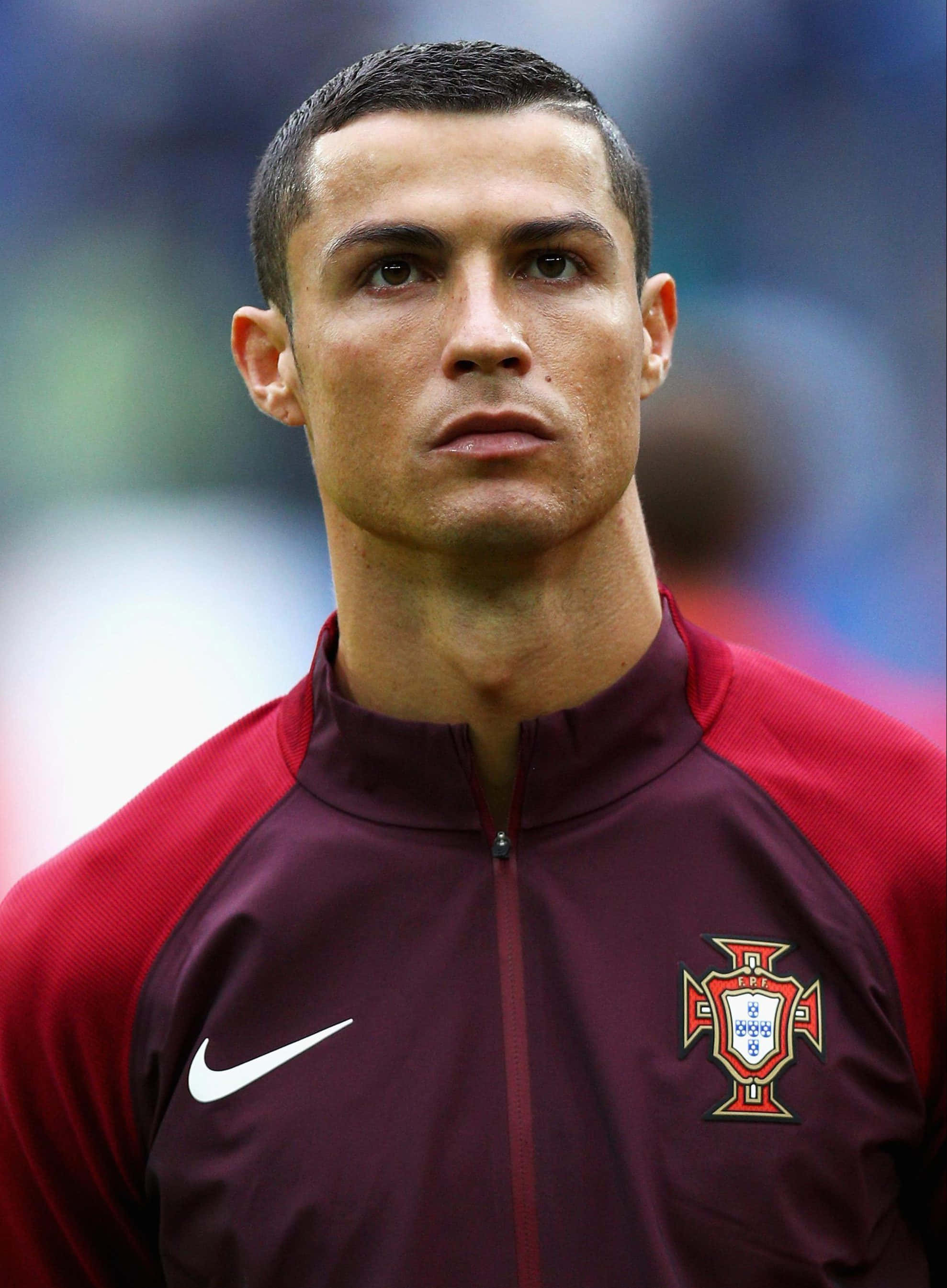 Ronaldo 桌布 壁紙 — 基斯坦奴·朗拿度的近距離肖像，身穿栗色和紅色的葡萄牙訓練外套，表情專注。