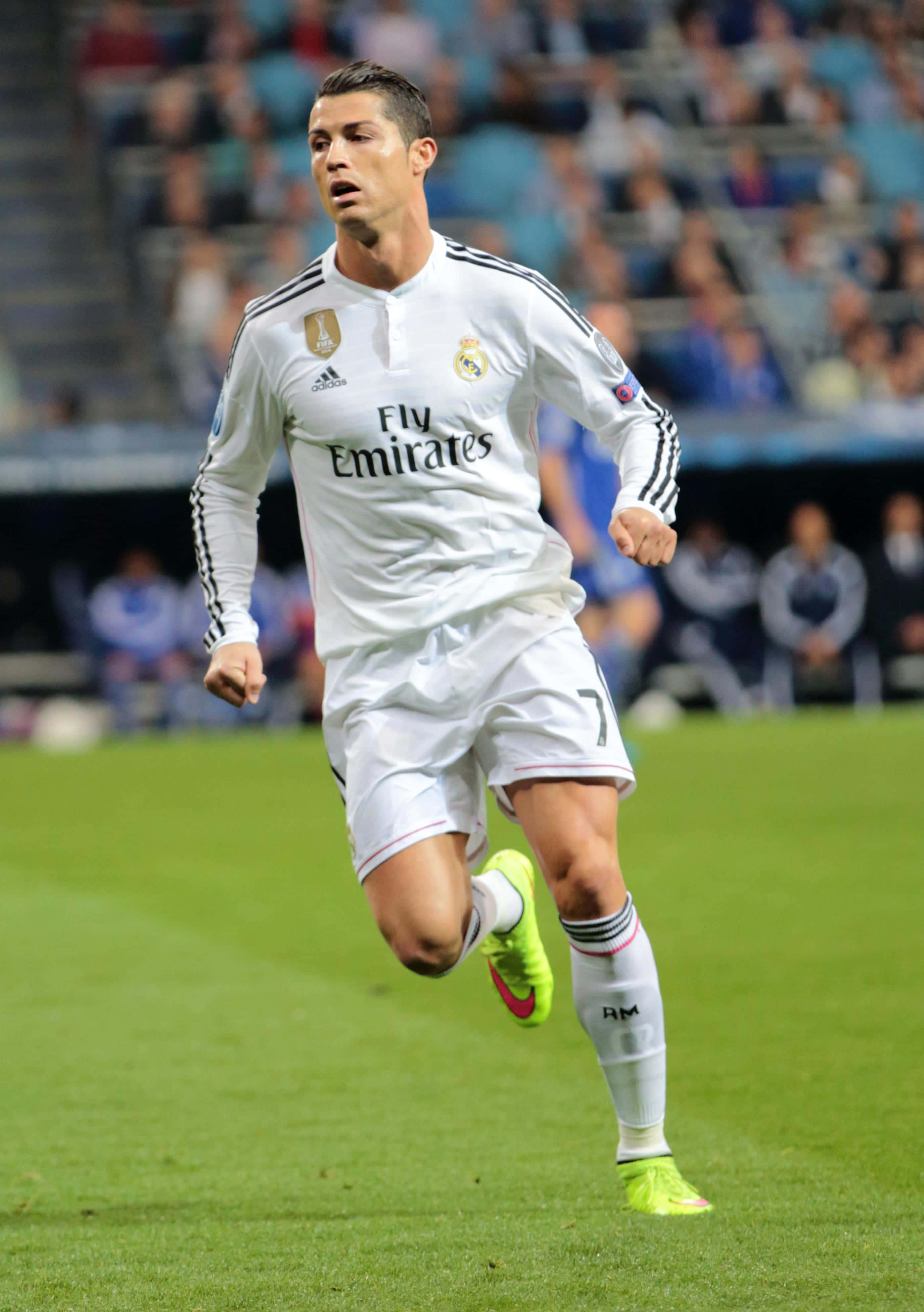Ronaldo 桌布 壁紙 — 基斯坦奴·朗拿度身穿白色皇家馬德里球衣，在球場燈光下於充滿活力的綠色草地上奔跑。