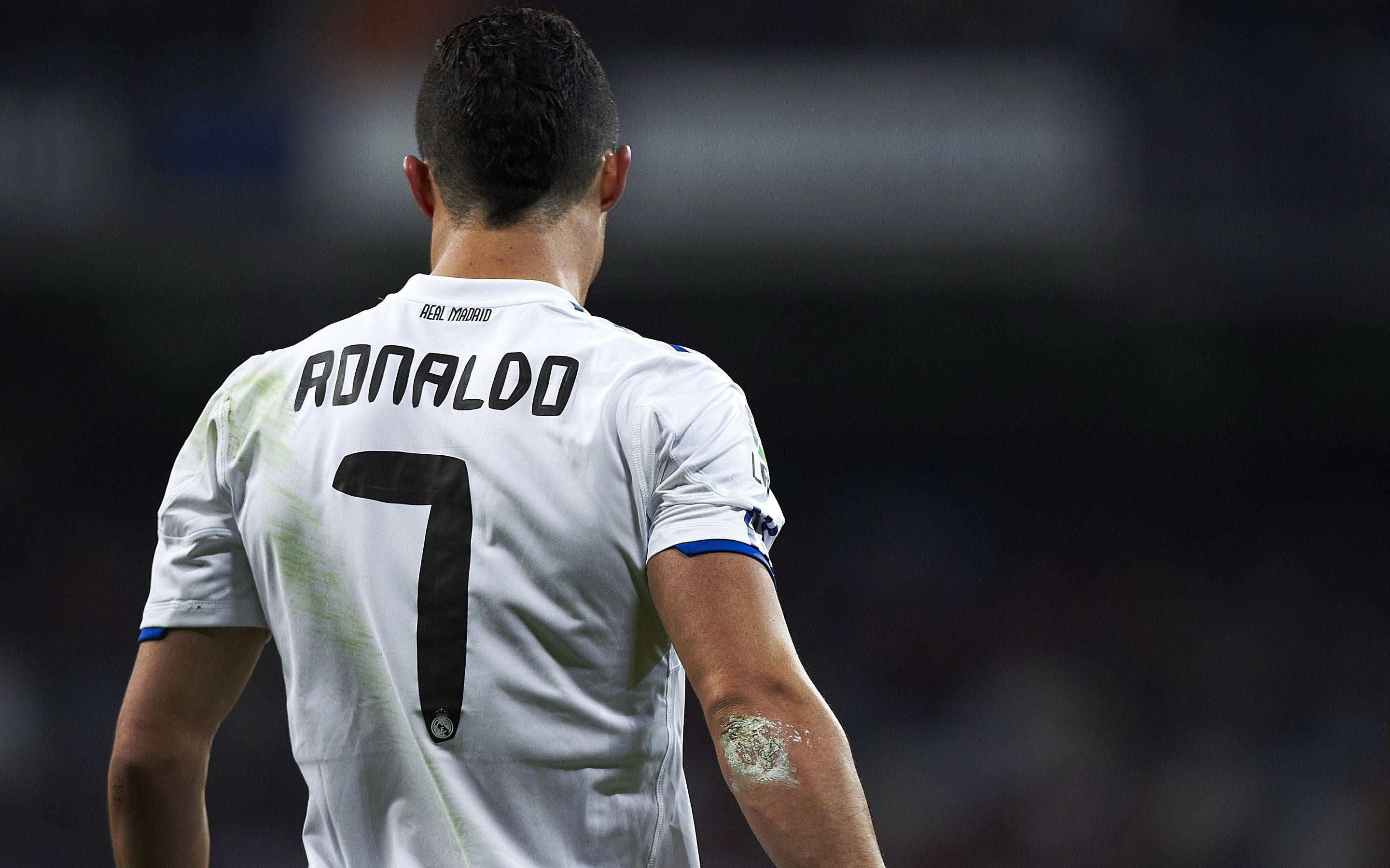 Cr7 桌布 壁紙 — 基斯坦奴·朗拿度身穿白色皇家馬德里7號球衣，在模糊的球場上走開的背影。