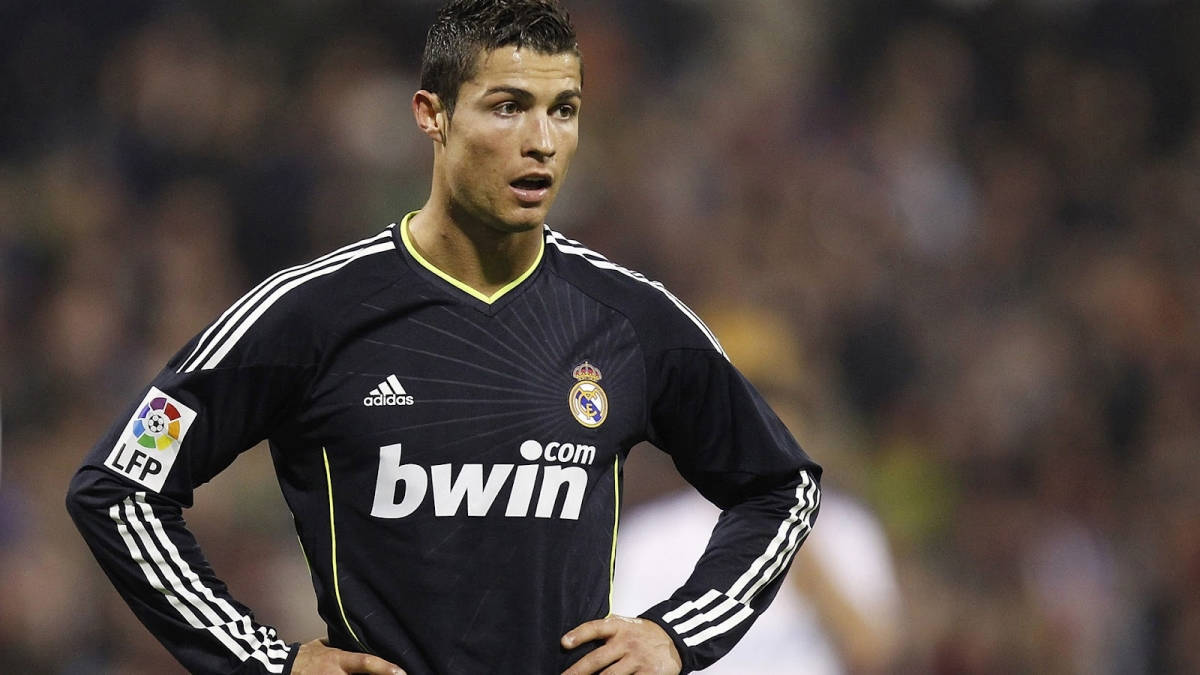 Ronaldo 桌布 壁紙 — 基斯坦奴·朗拿度身穿黑色皇家馬德里球衣，在夜間足球比賽中雙手叉腰，專注地站立。
