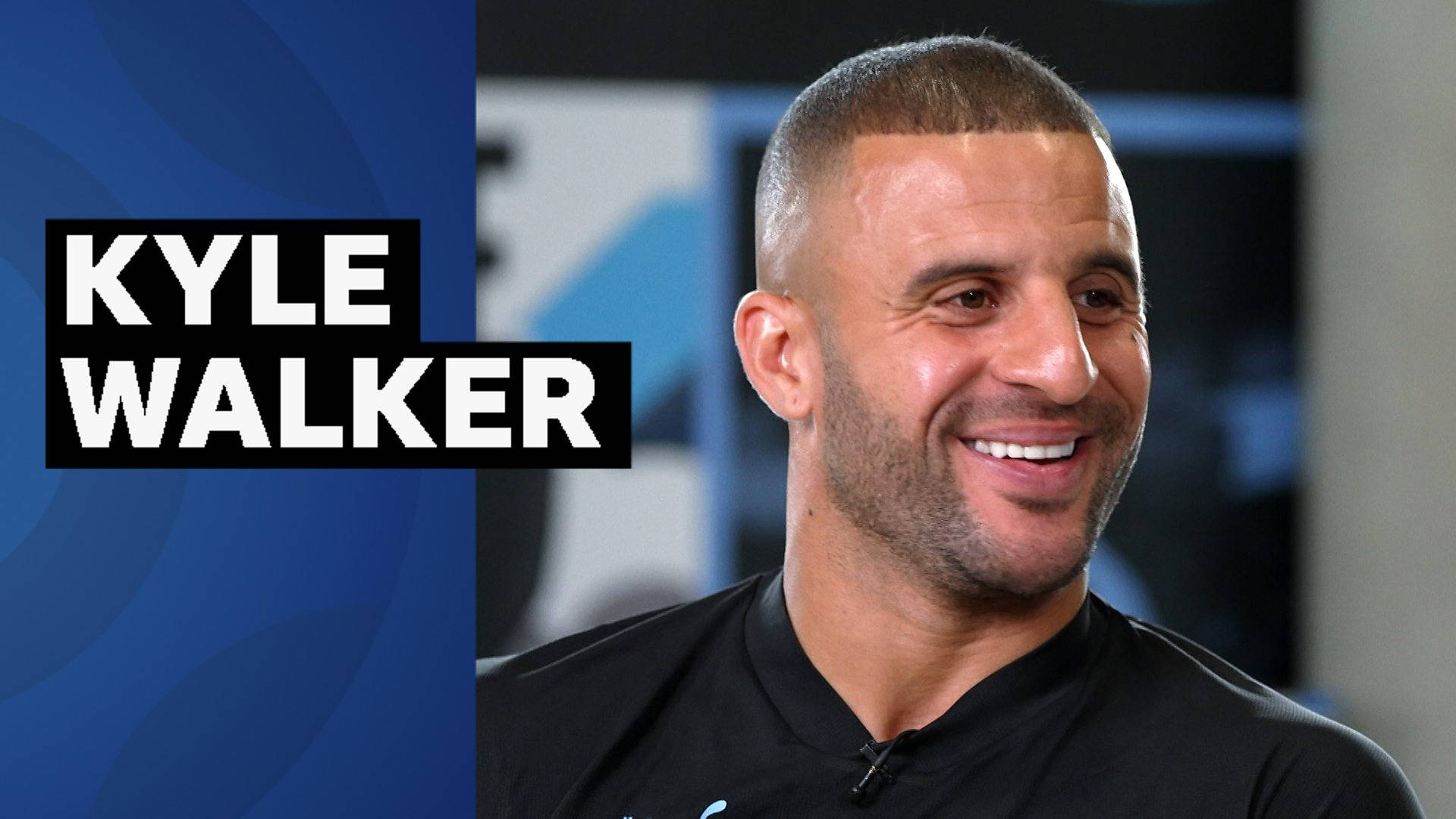 Kyle Walker 桌布 壁紙 — 基爾·沃克身穿黑色襯衫，在藍色圖形背景上微笑，並顯示他的名字。