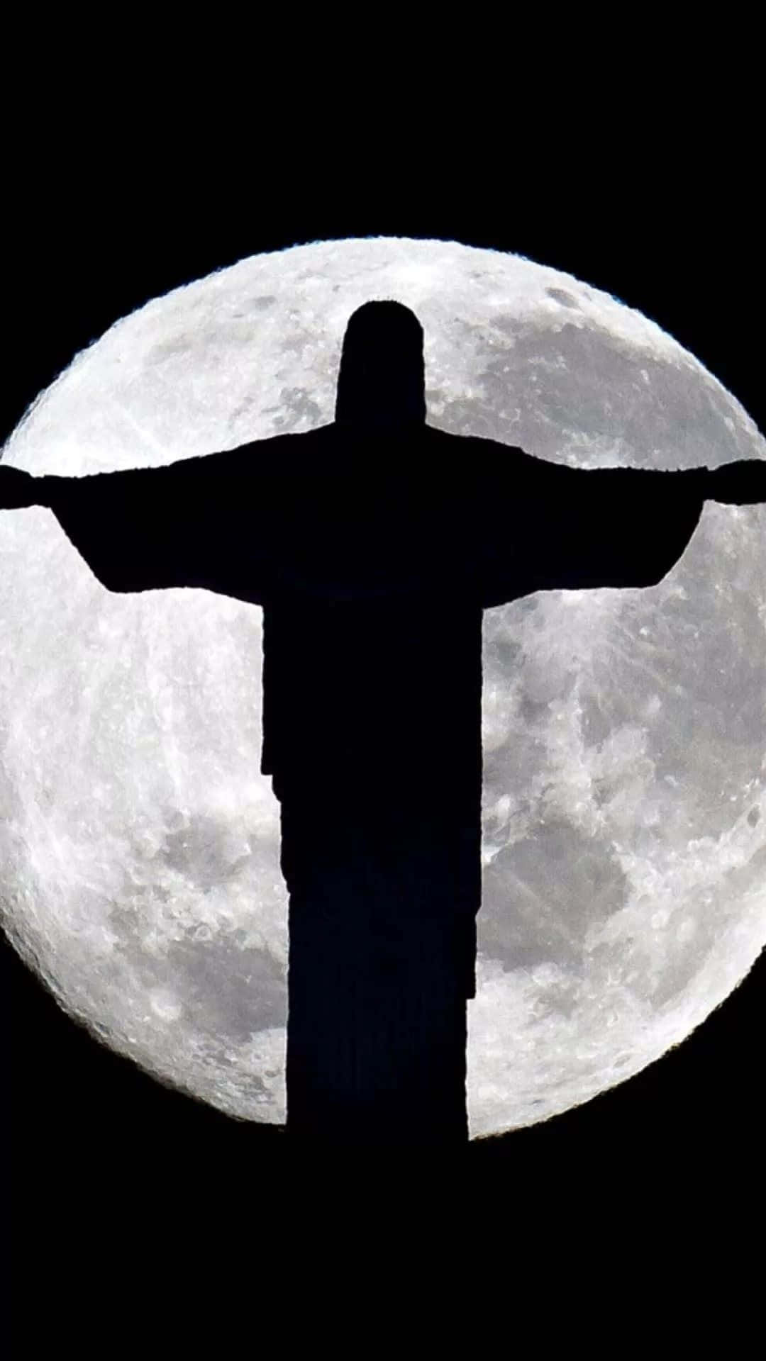 Jesus iPhone 桌布 壁紙 — 基督救世主雕像的剪影，在漆黑天空中襯托著巨大而詳細的滿月。