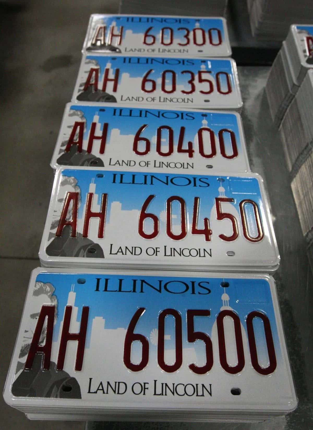 License Plate 桌布 壁紙 — 堆疊的伊利諾州車牌，序列號 AH 60300 至 60500，展示「Land of Lincoln」標語和城市天際線設計。