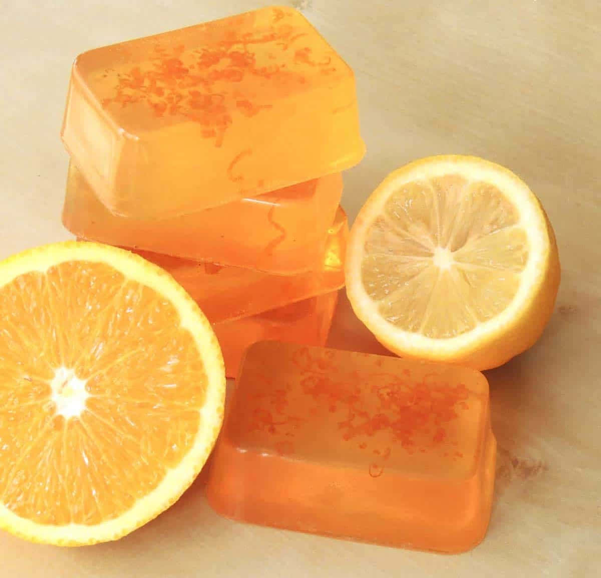bath 桌布 壁紙 — 堆疊的橙色柑橘肥皂條，旁邊放著半個柳橙和檸檬，露出多汁的果肉。