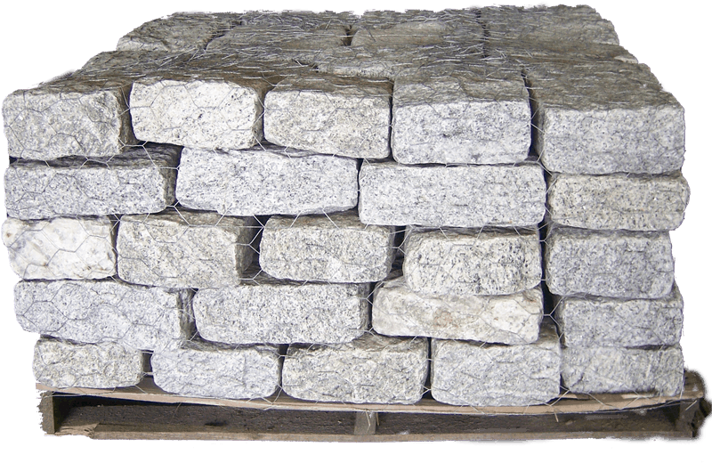 Blocks 桌布 壁紙 — 堆疊的灰色花崗岩鋪路石，用金屬網捆綁，放在木棧板上，背景為黑色。