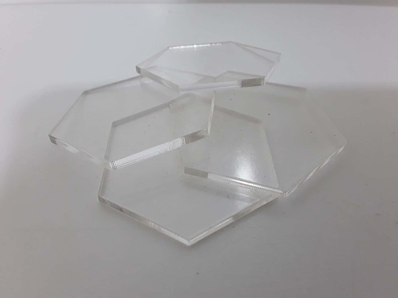 Shapes 桌布 壁紙 — 堆疊的透明六角形壓克力片，邊緣鋒利，在純白表面上帶有微妙反射。